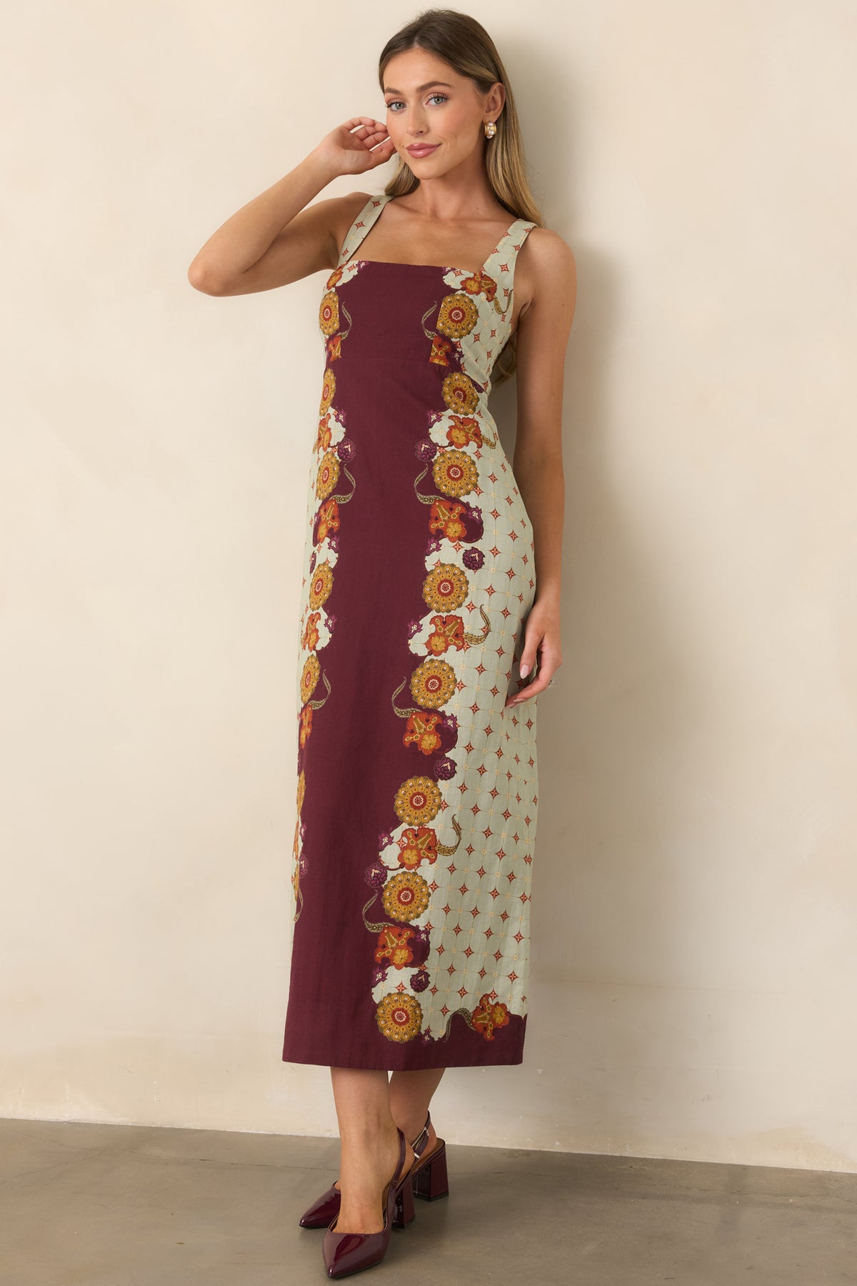 Wine floral dress highlighted by pale sage panels and an elegant flared midi silhouette.