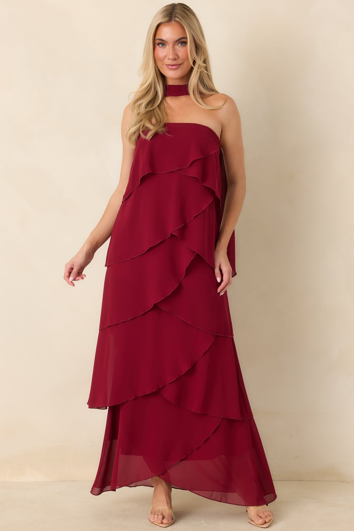 Wine red dress with a fitted strapless bodice and flowing asymmetrical ruffles.