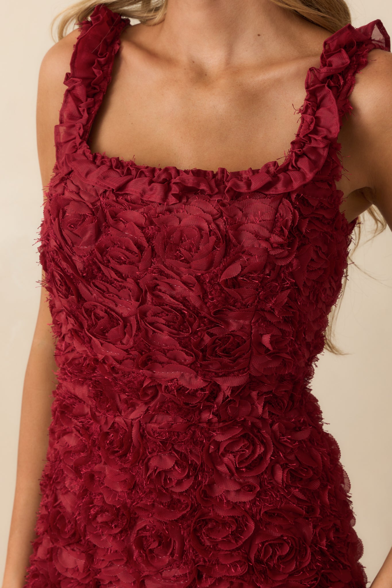 Close-up of the 3D floral appliques and ruffle texture on the wine red fabric.