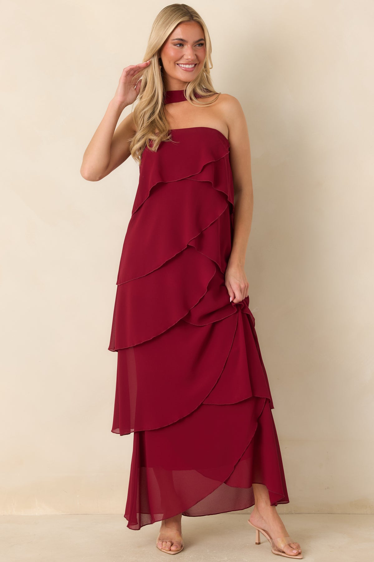 Wine red maxi dress with an angled ruffle design and coordinating scarf draped around the neck.