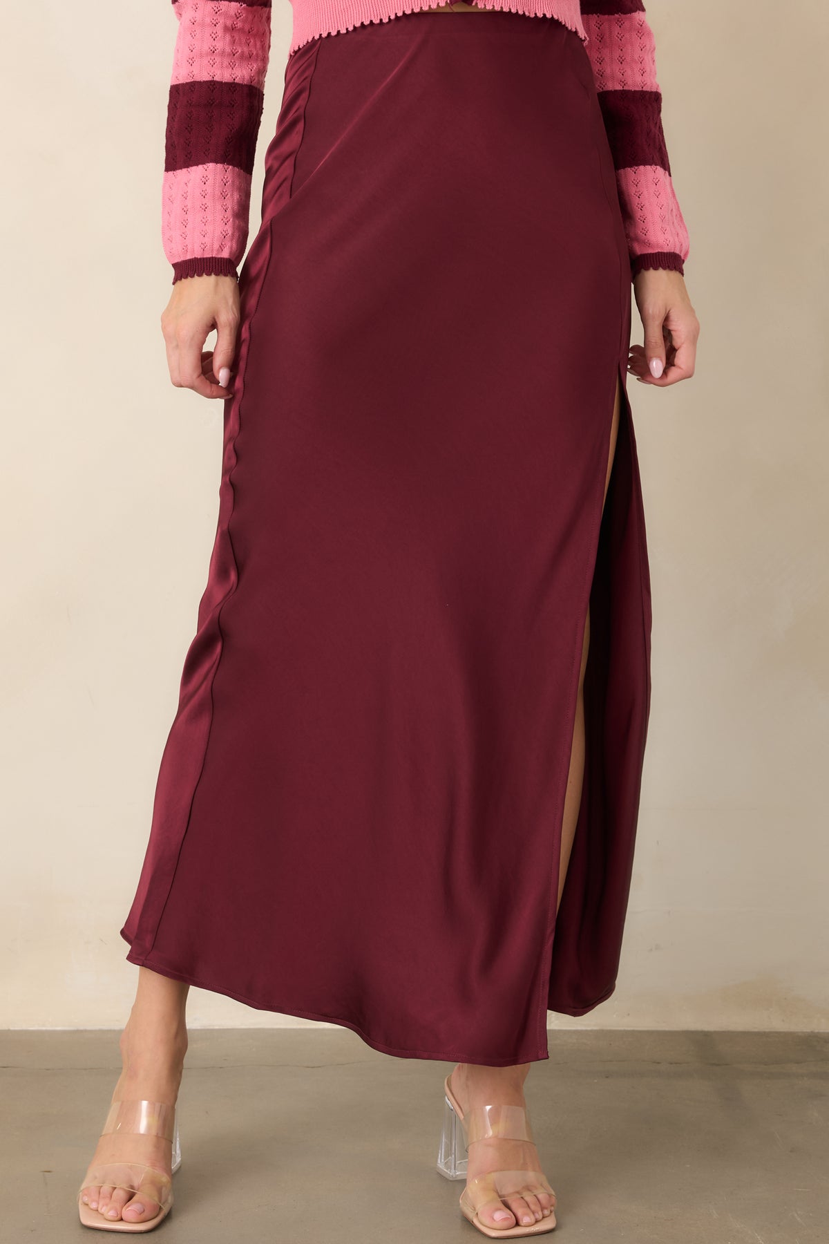 Rich wine satin skirt showcasing the smooth high-rise waist and sleek pull-on construction.
