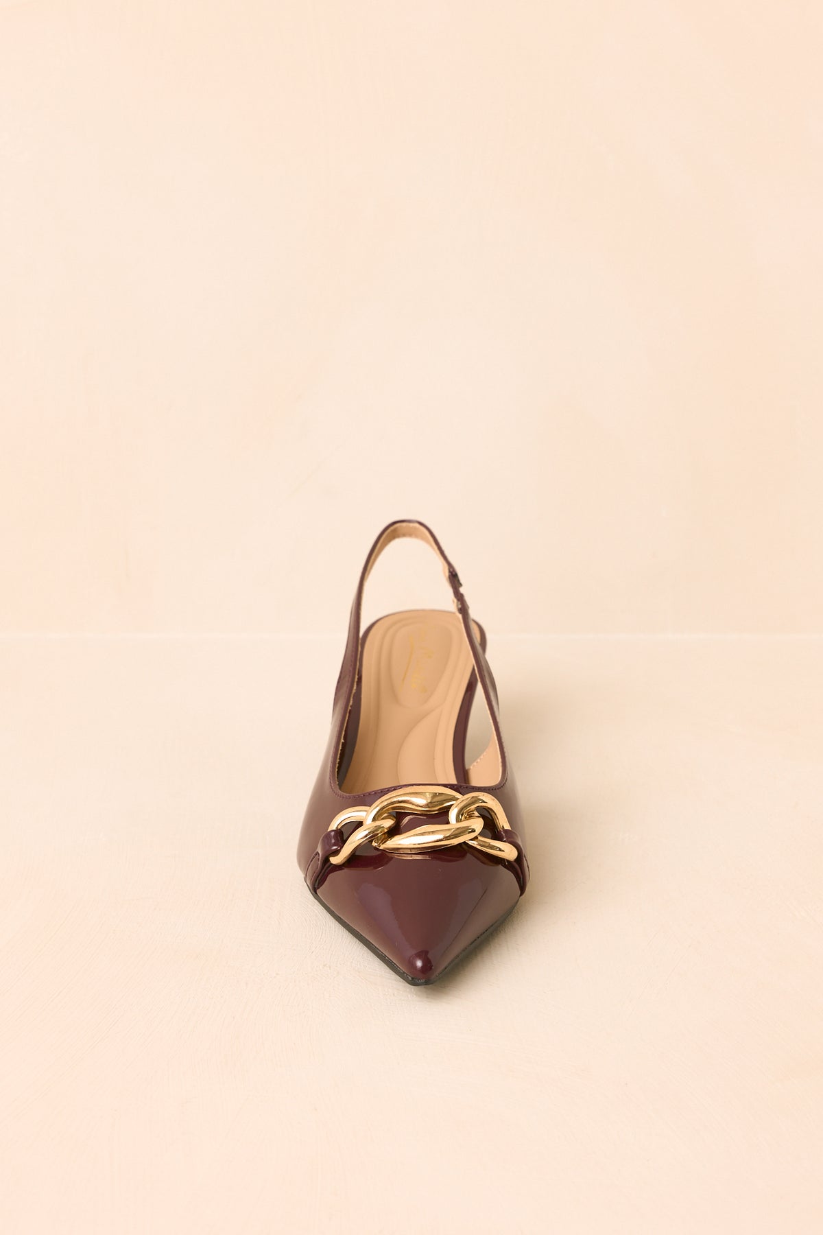 Wine-toned patent slingback heels with a streamlined pointed toe, oversized chain accent, and comfortable low kitten heel.