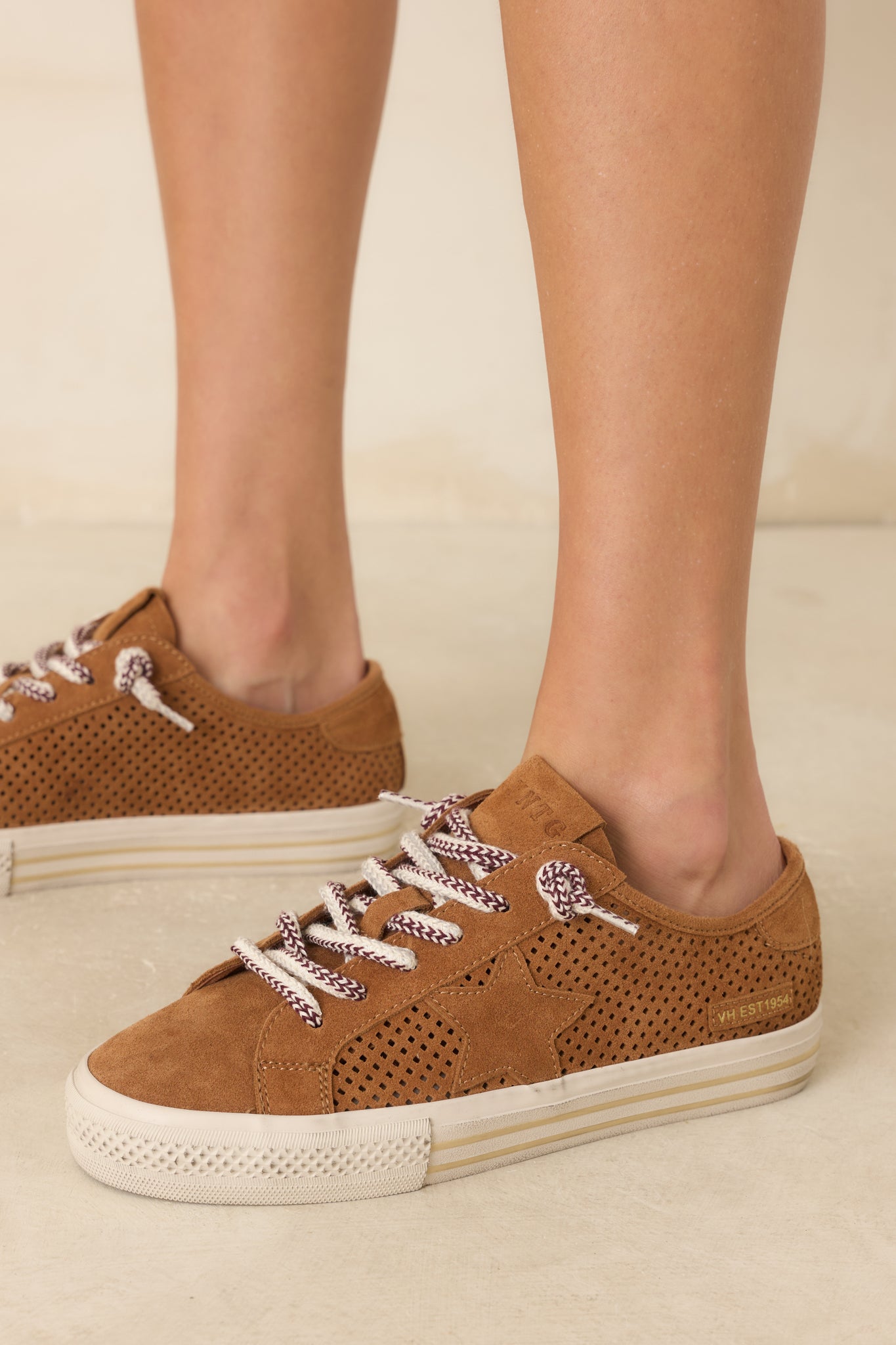 Women's camel brown perforated suede lace-up sneakers with a star detail,white platform sole, and multicolor laces.