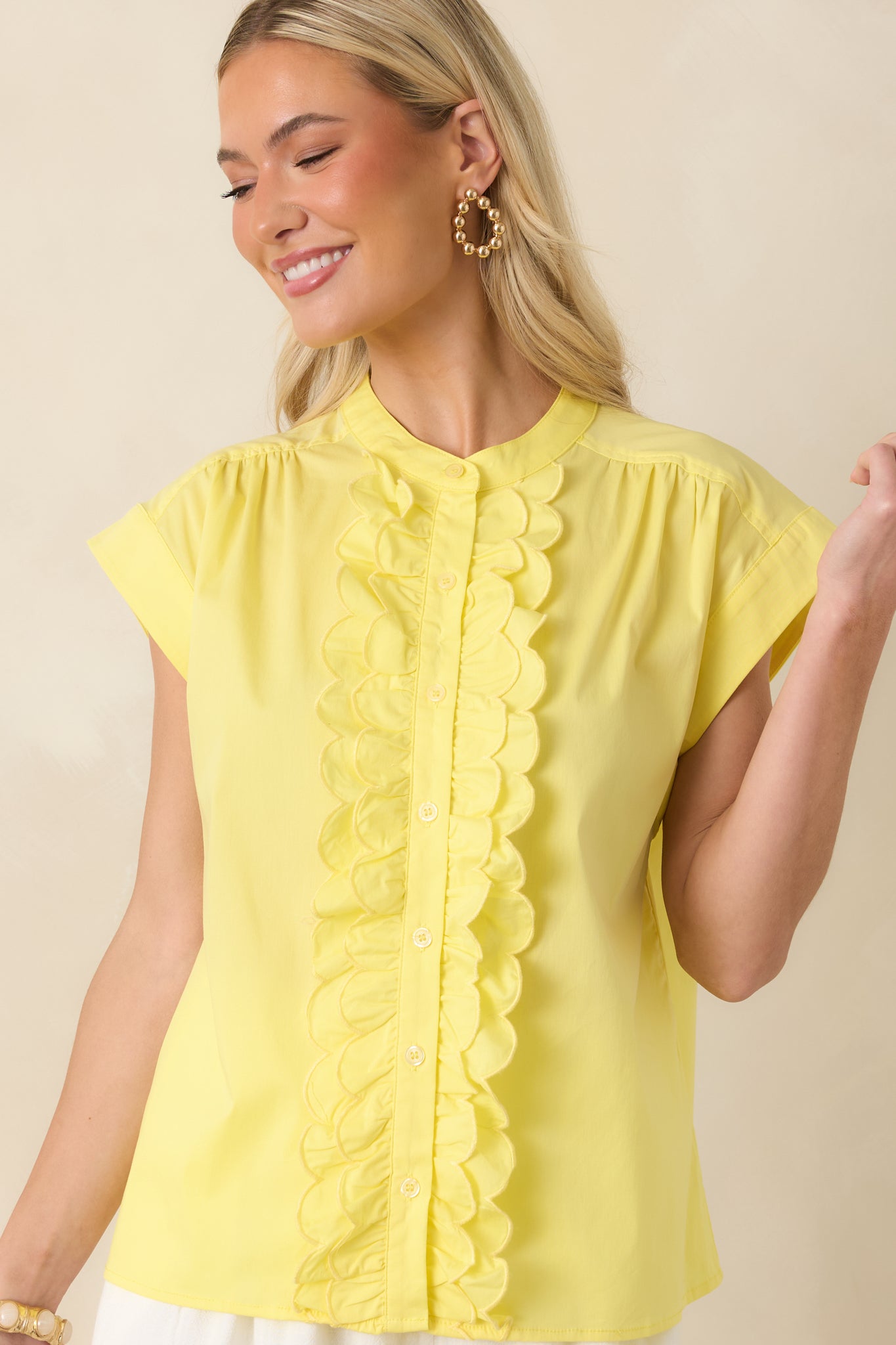 Yellow cotton blend top focusing on cuffed cap sleeves and soft seam gathering at the shoulders for a refined finish.