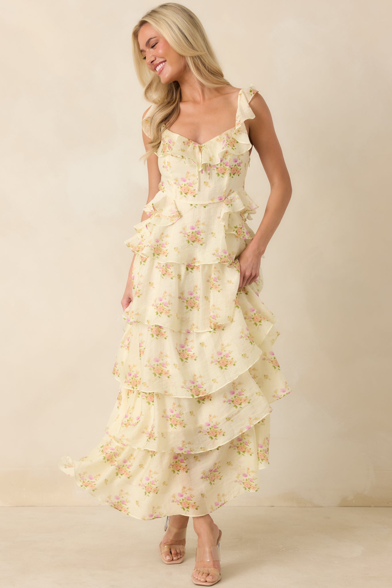 Yellow floral maxi dress featuring adjustable ruffle-trim spaghetti straps, a decorative bow neckline, and a tiered skirt.
