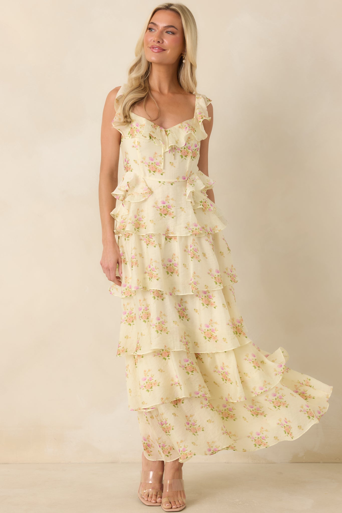 Maxi dress designed with a soft yellow floral pattern, adjustable straps, and graceful movement through the skirt.