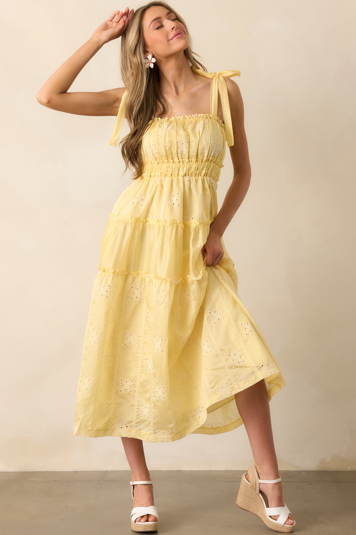 This charming yellow midi dress includes functional pockets and intricate embroidered eyelet detailing.