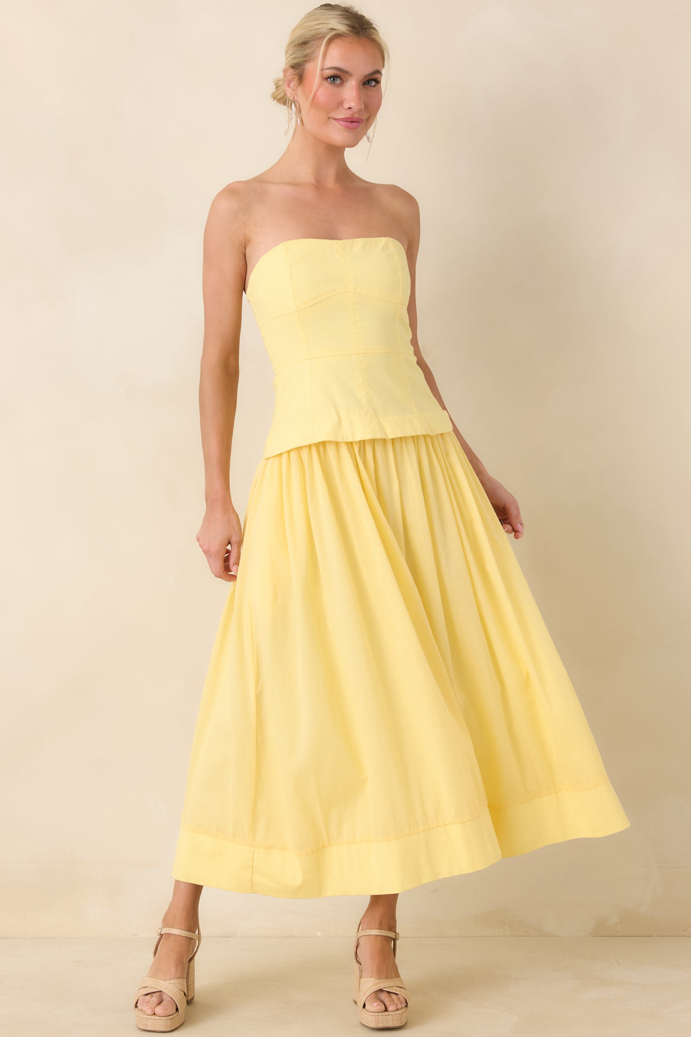 Cheerful yellow midi dress with structured bustier detailing and a softly flared skirt that creates a balanced, feminine silhouette.