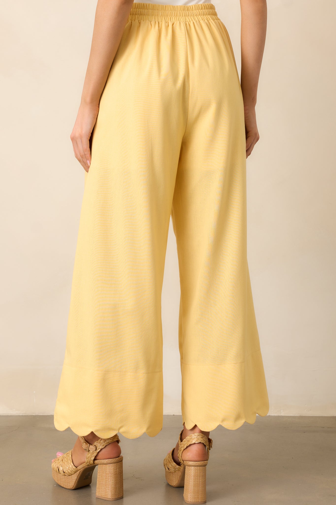 The yellow pants continue their breezy wide-leg fit in the back, completing their relaxed yet stylish appeal.