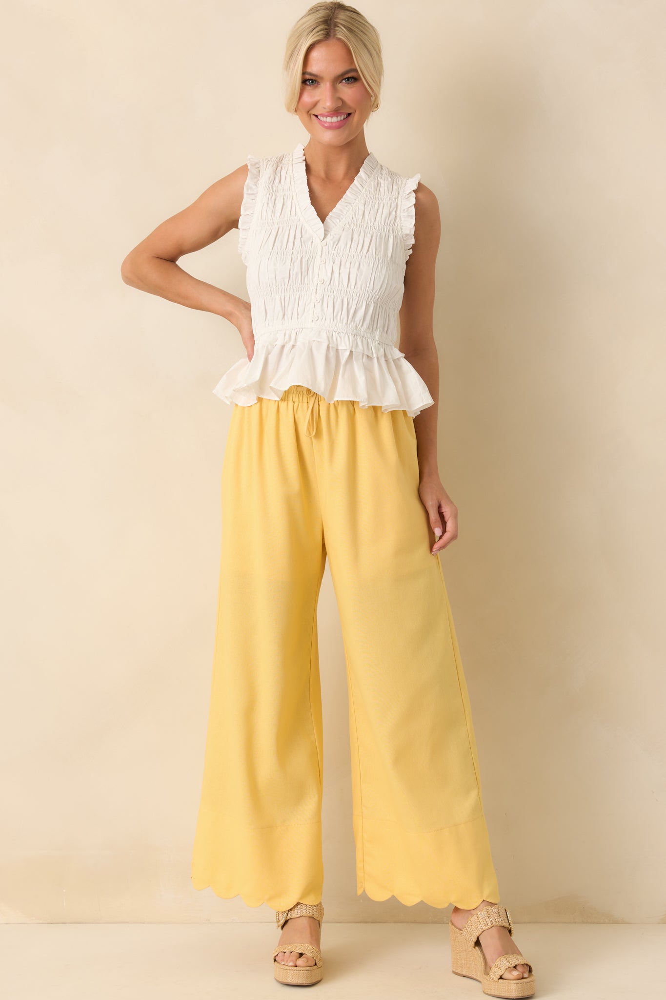 A front-facing view of the yellow pants highlighting the relaxed wide leg fit, tied waist detail, and soft drape of the fabric.
