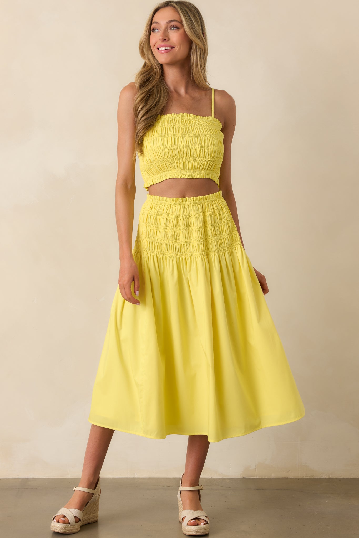 Full-body view of the yellow top showcasing its cropped length and fitted smocked bodice.