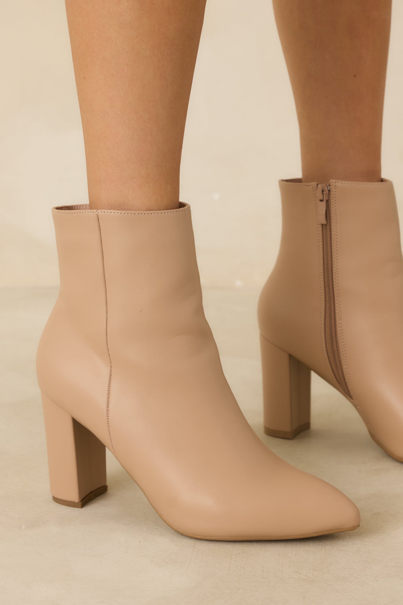 Close-up showing the zipper, outer seam, and block heel texture.