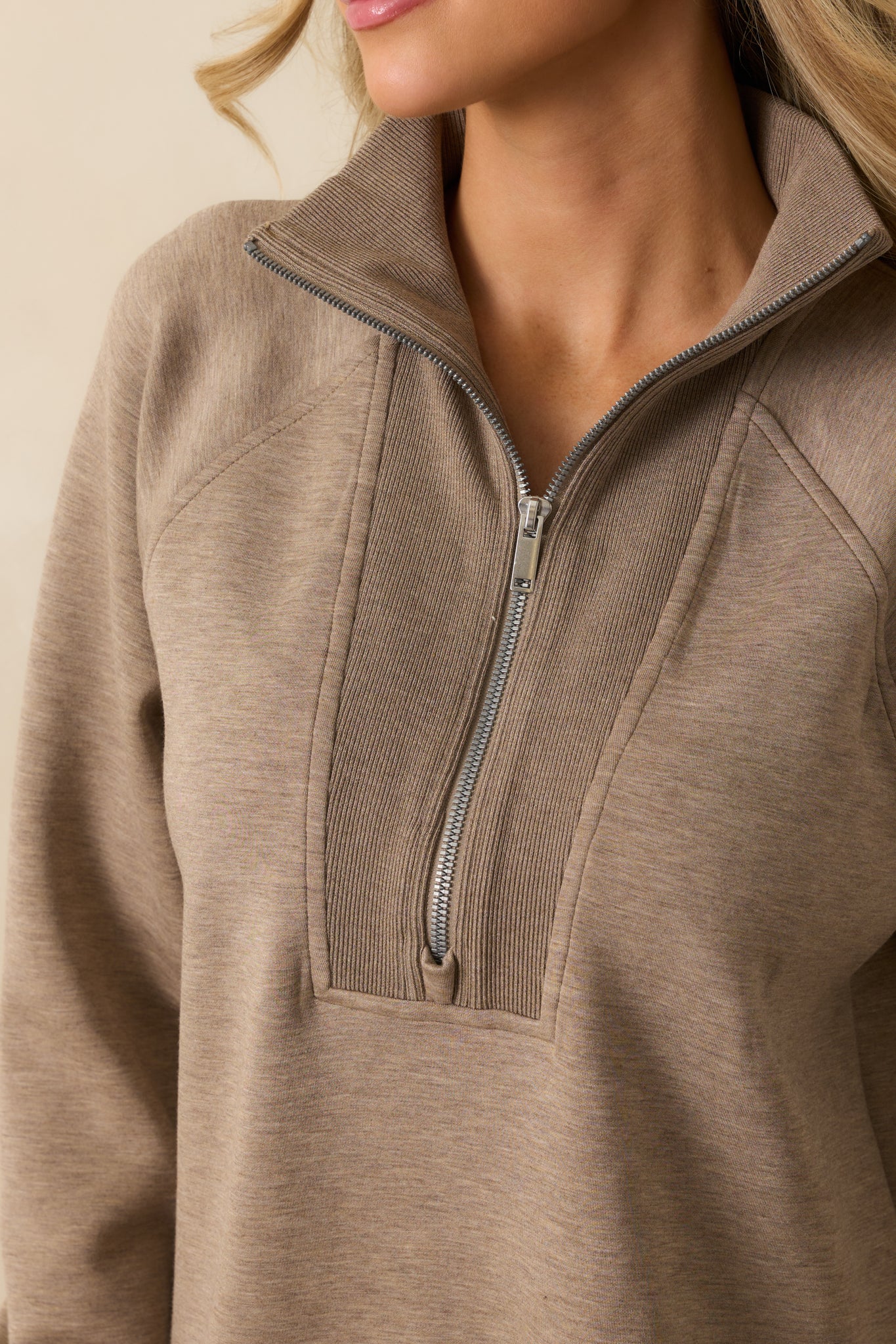 Zoomed-in look at the brushed performance knit fabric and ribbed trim in taupe.