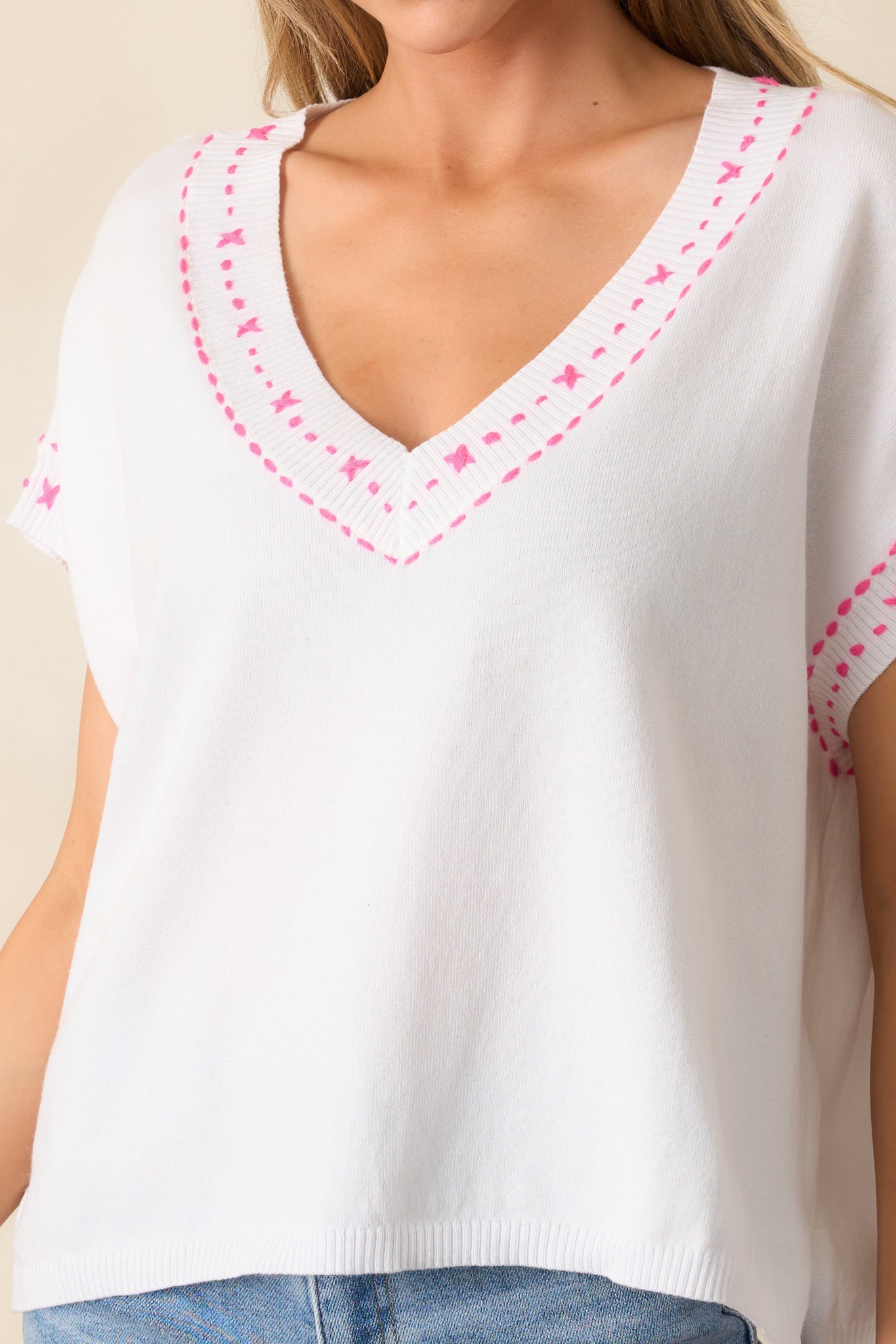 A zoomed-in view of the fabric texture, showcasing the precise pink embroidery and soft material.