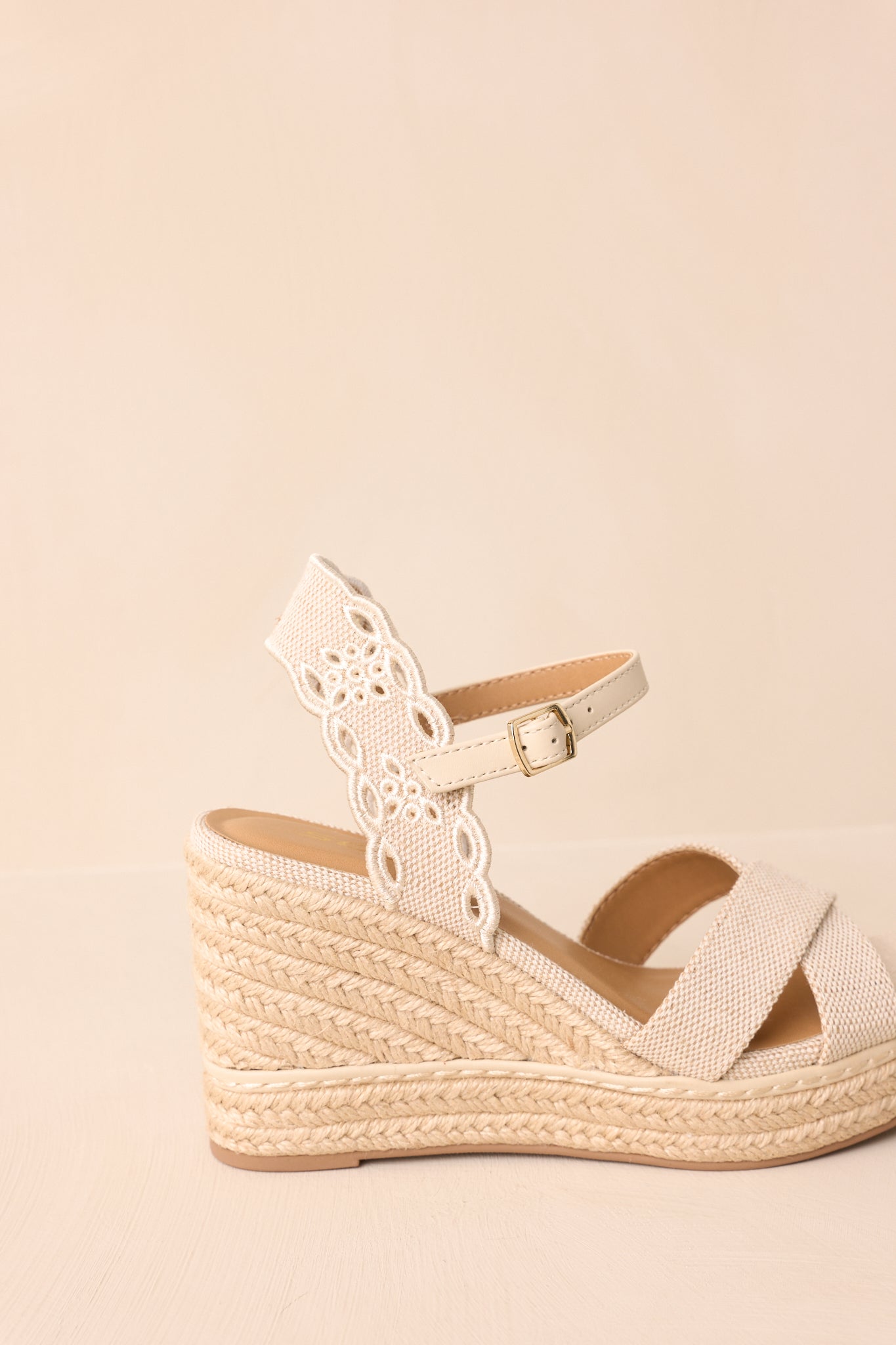 A zoomed-in side view of the wedges, showing the jute wedge heel and embroidered design.