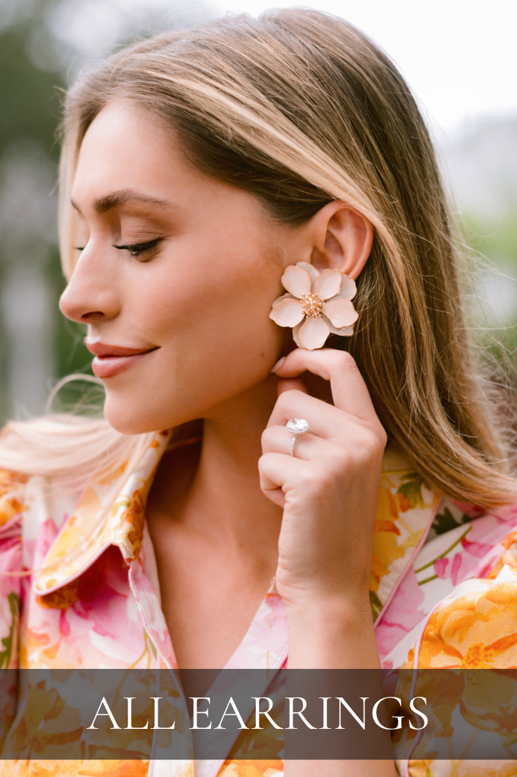 Close-up of model wearing large floral statement earrings. Earrings featured in All Earrings Collection