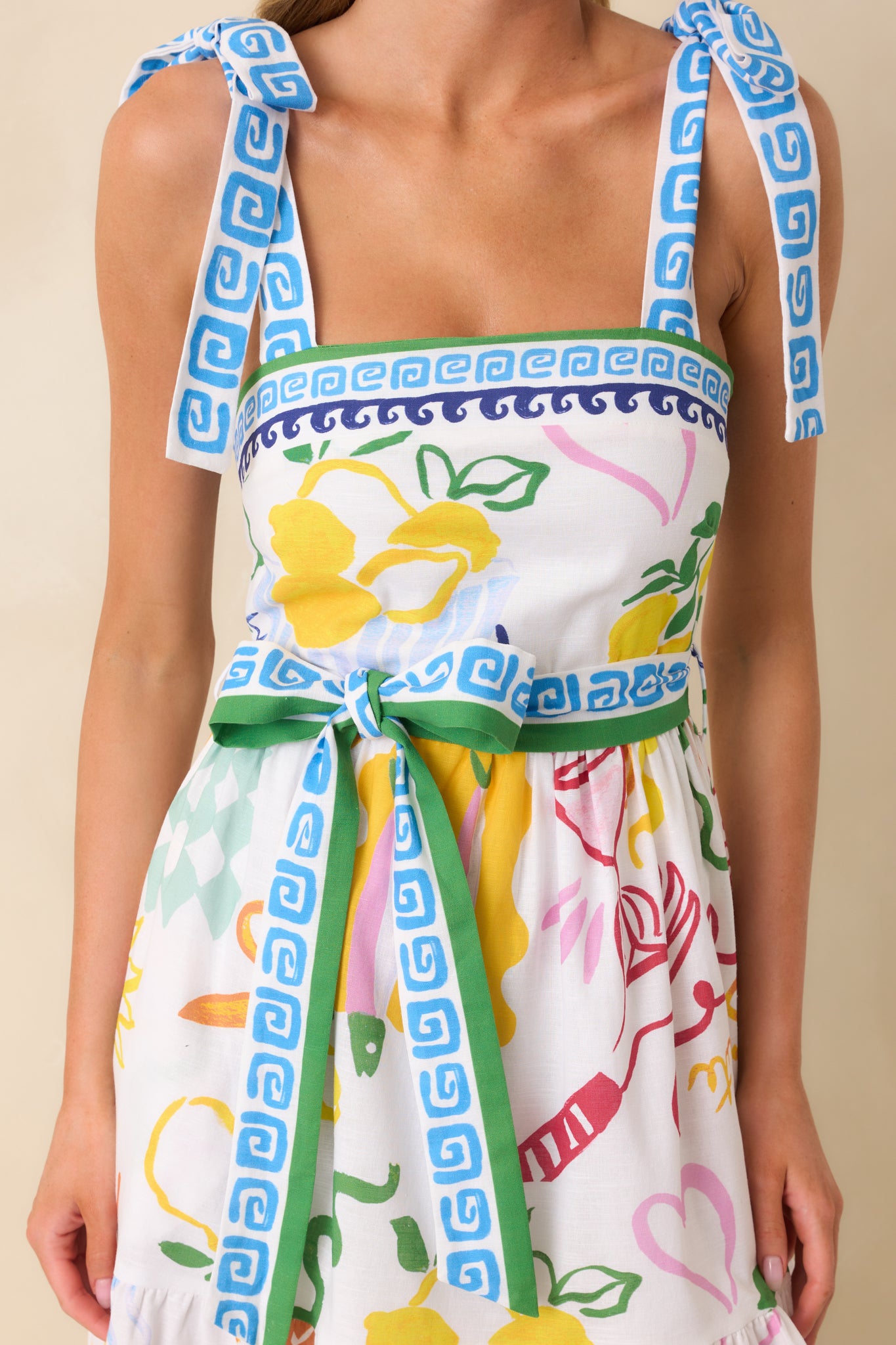 Close-up of the upper bodice, capturing the square neckline, adjustable self-tie bow straps, and detailed view of the colorful print.