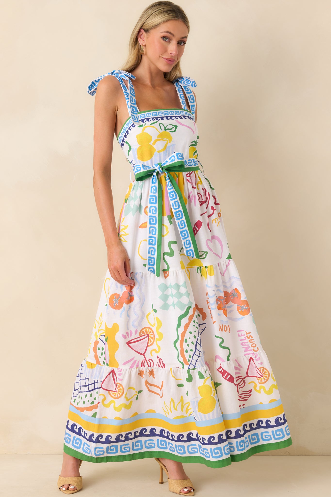 Slight angle of the full dress focusing on the bow-tied shoulder straps and vibrant multicolor pattern across the skirt.