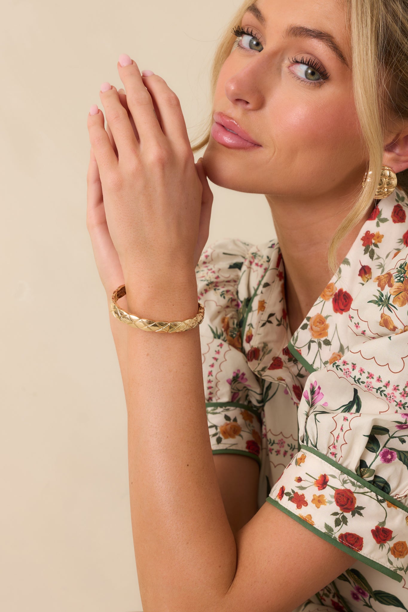 Close-up of the crisscross embossed pattern and gold-tone finish on the bangle.