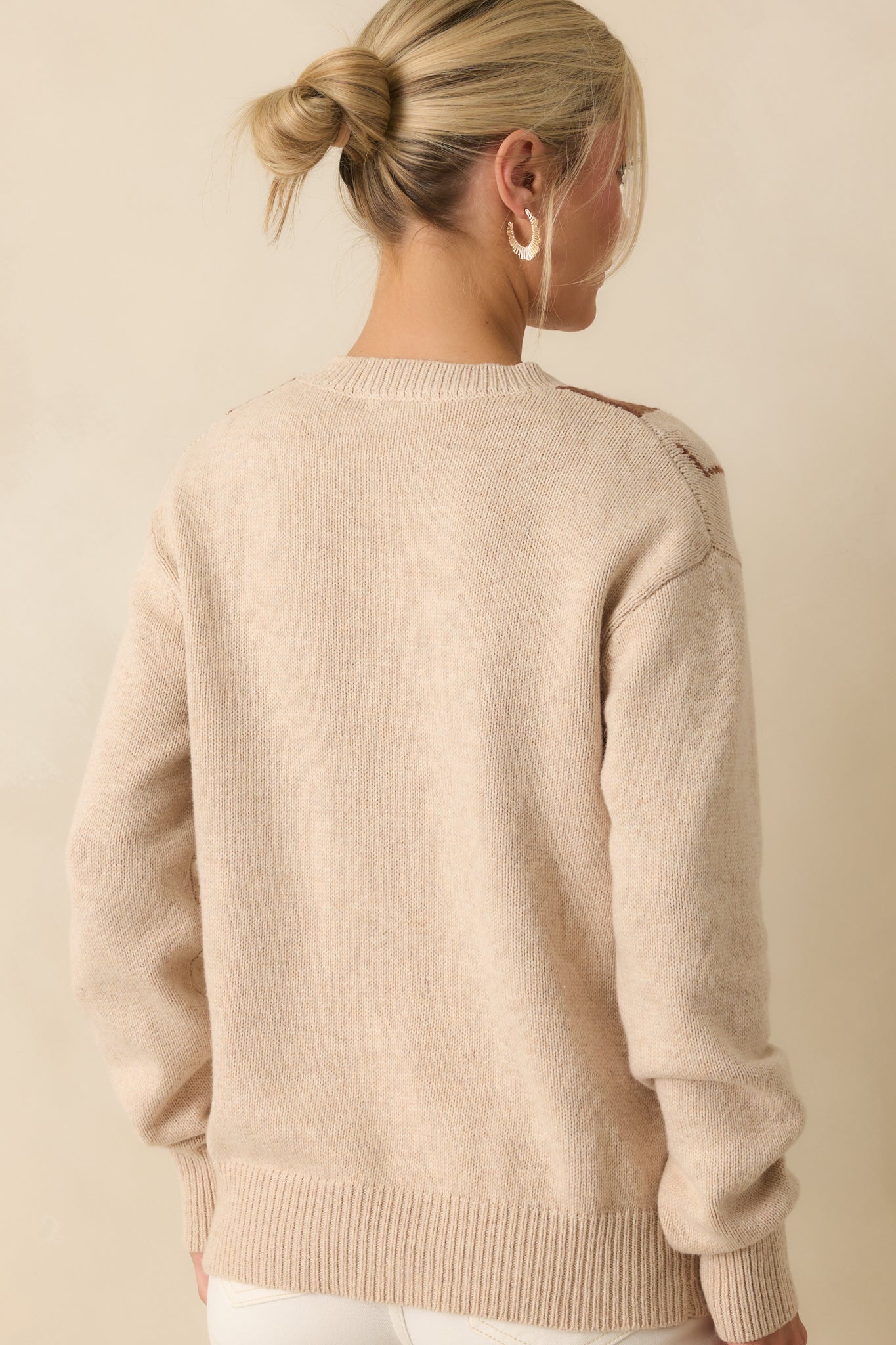 Rear view of the beige argyle sweater showing long sleeves and relaxed silhouette.