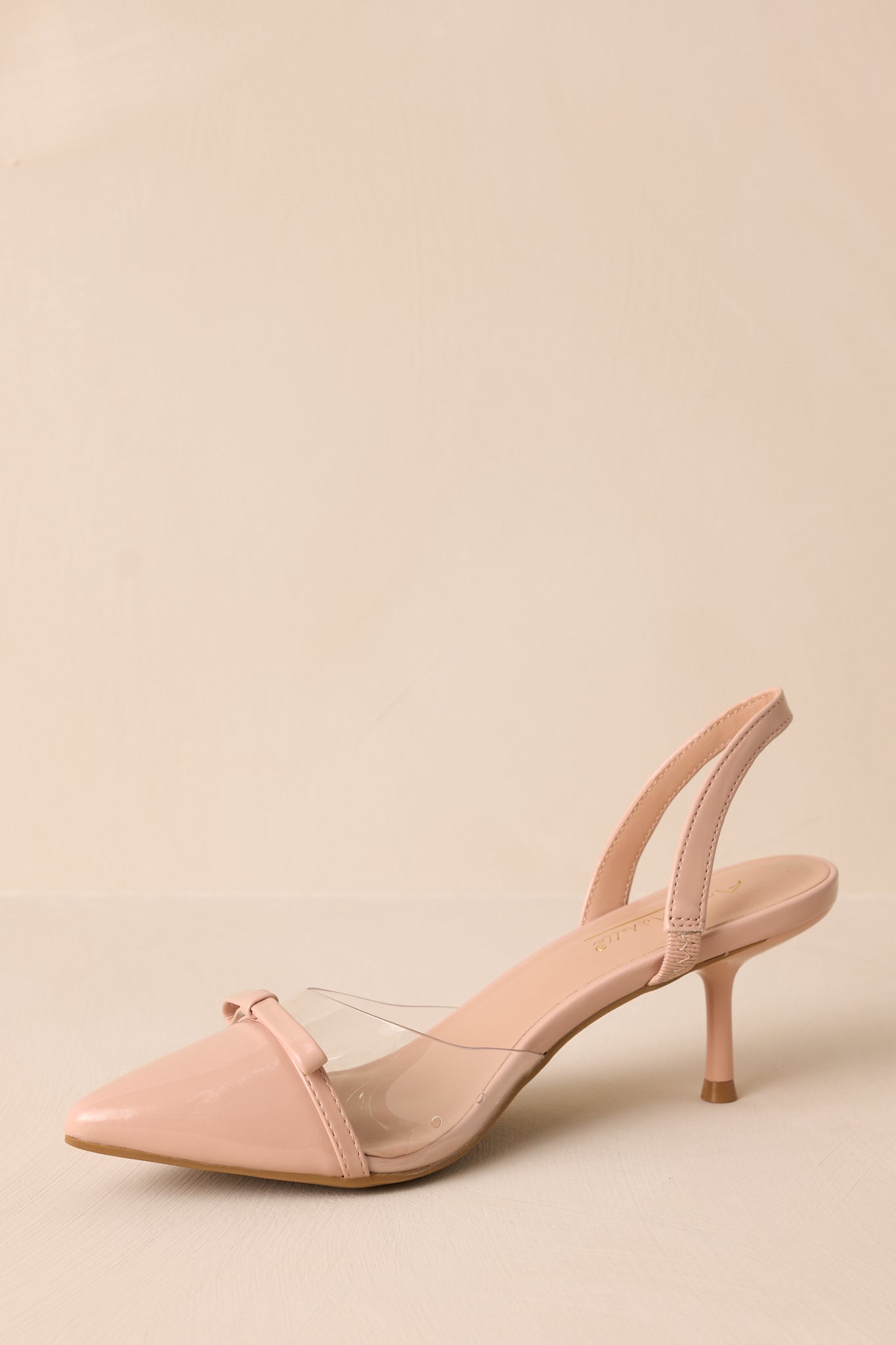 Side angle on a beige background highlighting the short kitten heel and clean lines