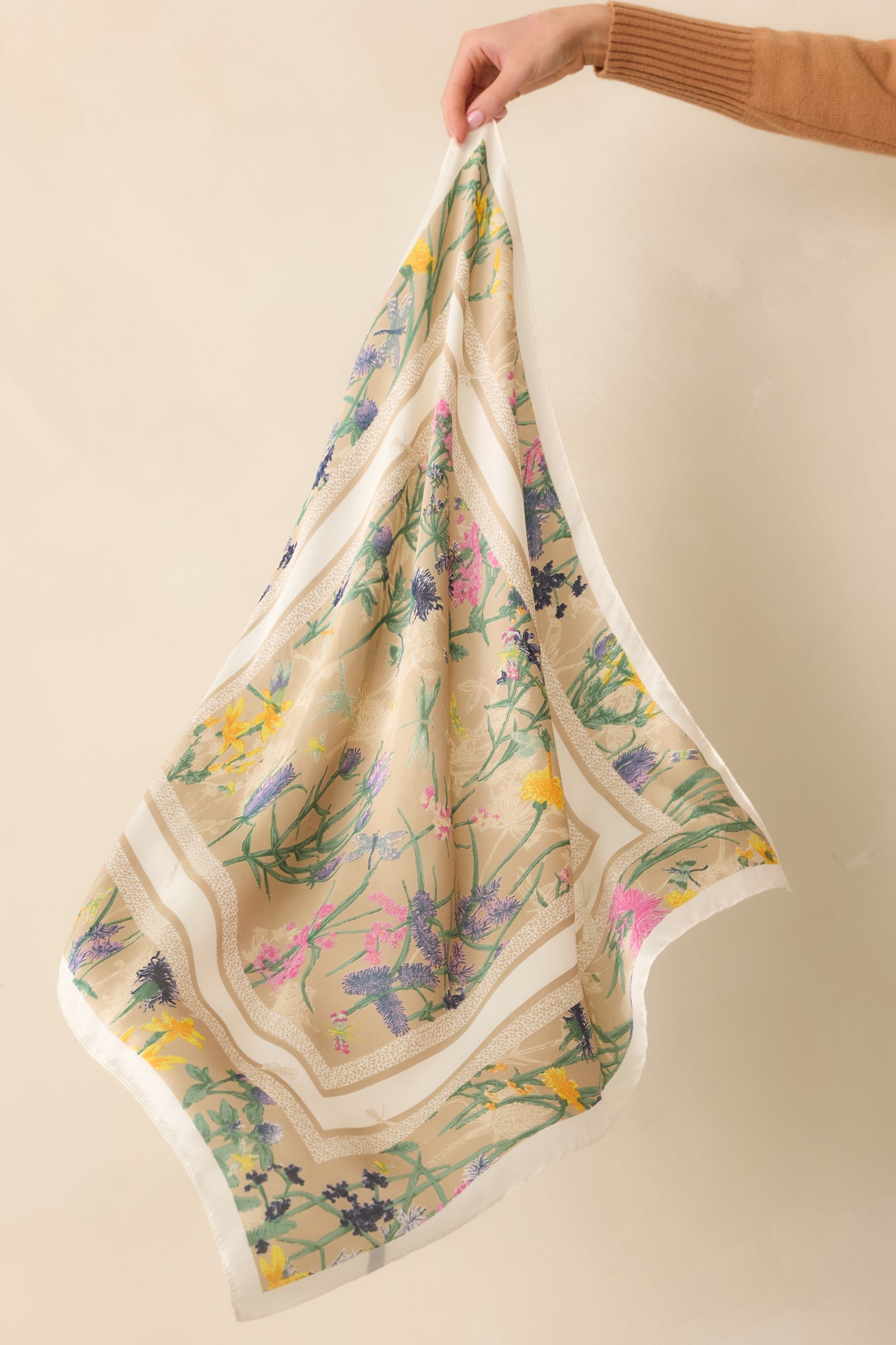 The satin beige scarf featuring vibrant floral patterns framed by an animal print border.