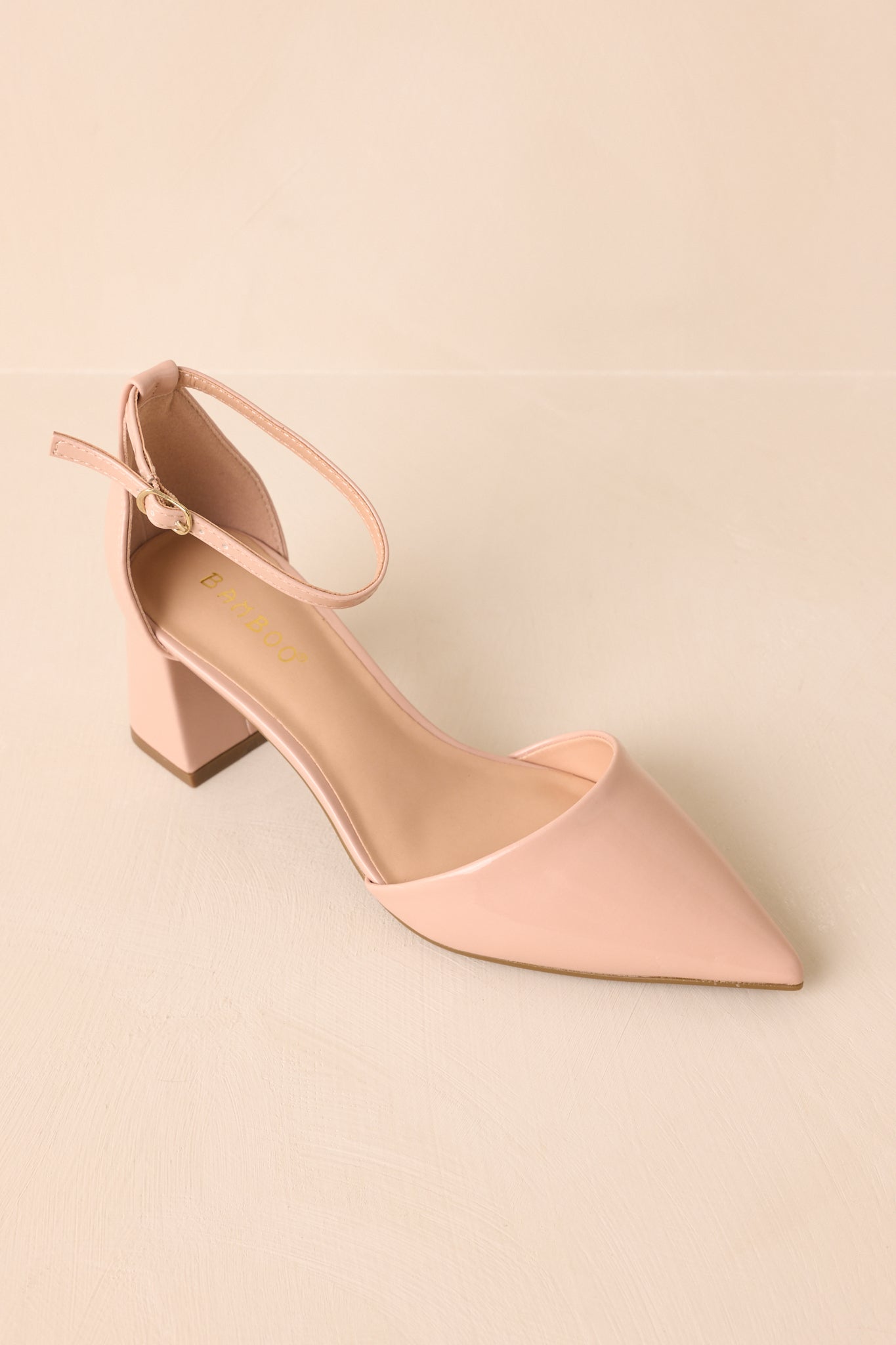 Top-down angle of the beige heels showing pointed toe shape and ankle strap layout.