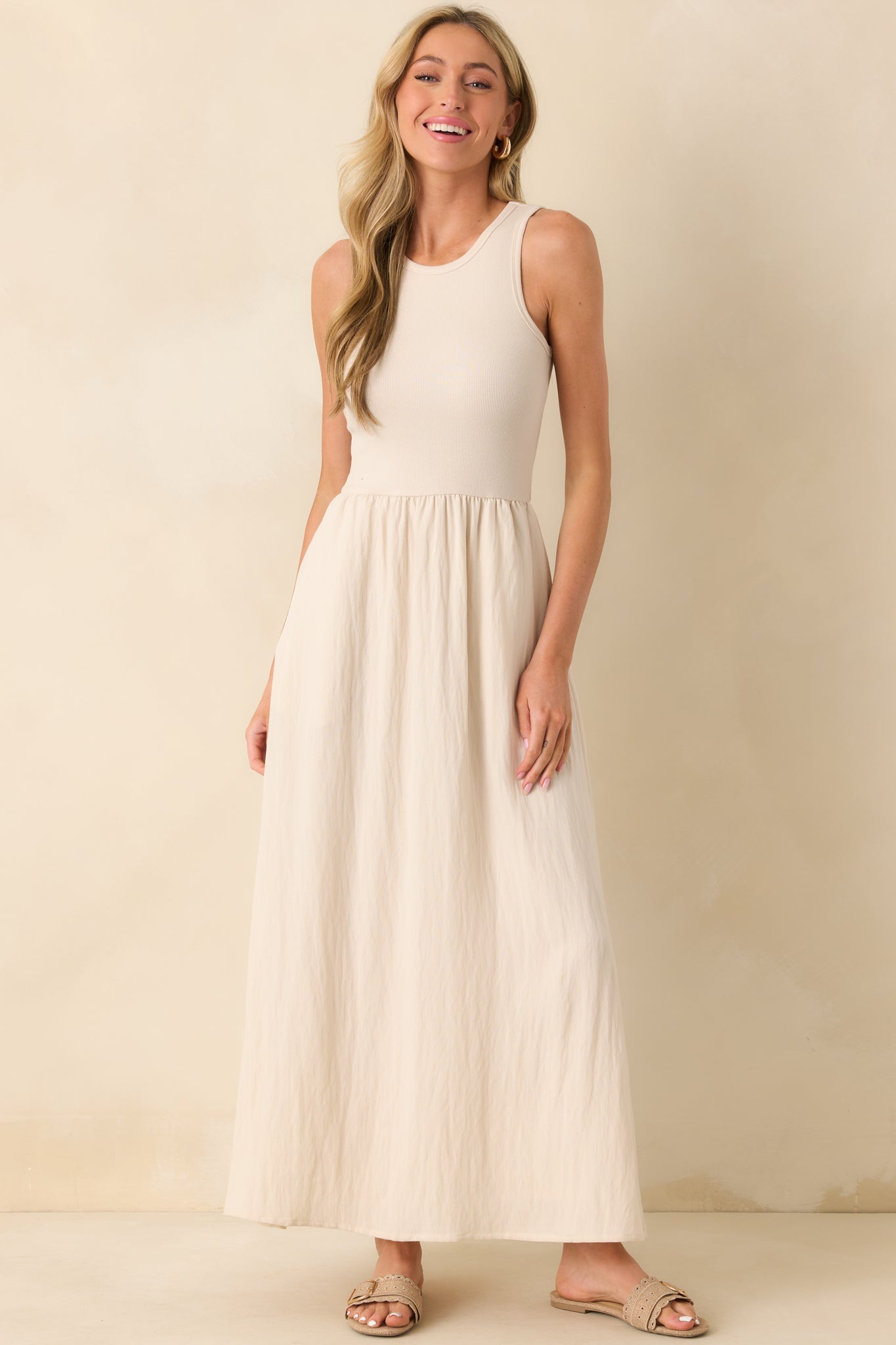 Slight side angle of the beige midi dress emphasizing the functional pockets and the flow of the midi-length skirt.