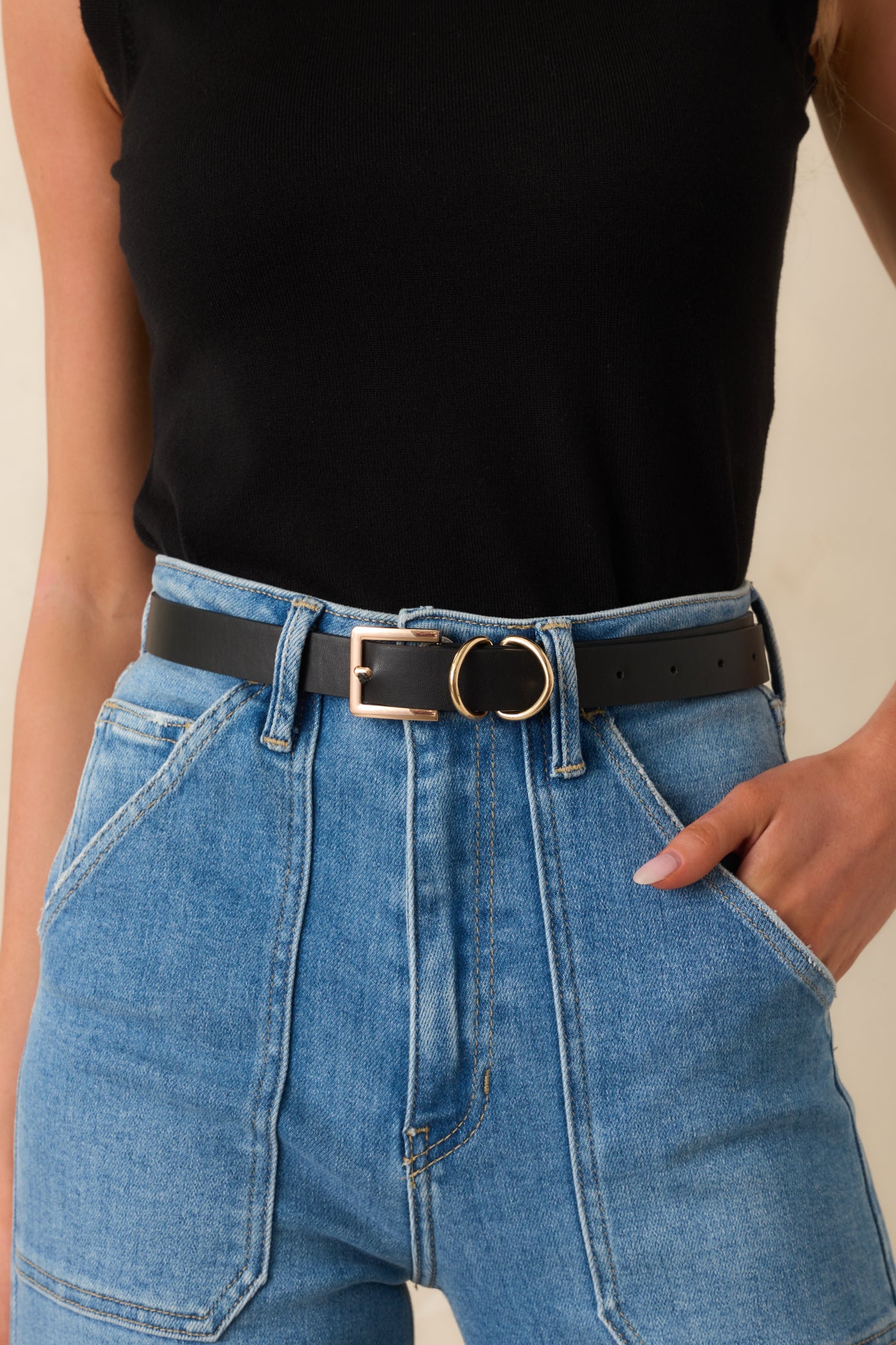 Cropped front view of the black belt showing the slim silhouette and polished gold-tone square buckle.