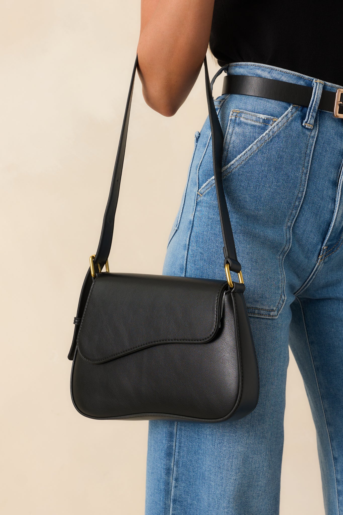 Angled full body shot highlighting the structured shape of the saddlebag, tonal topstitching, and front flap detail.