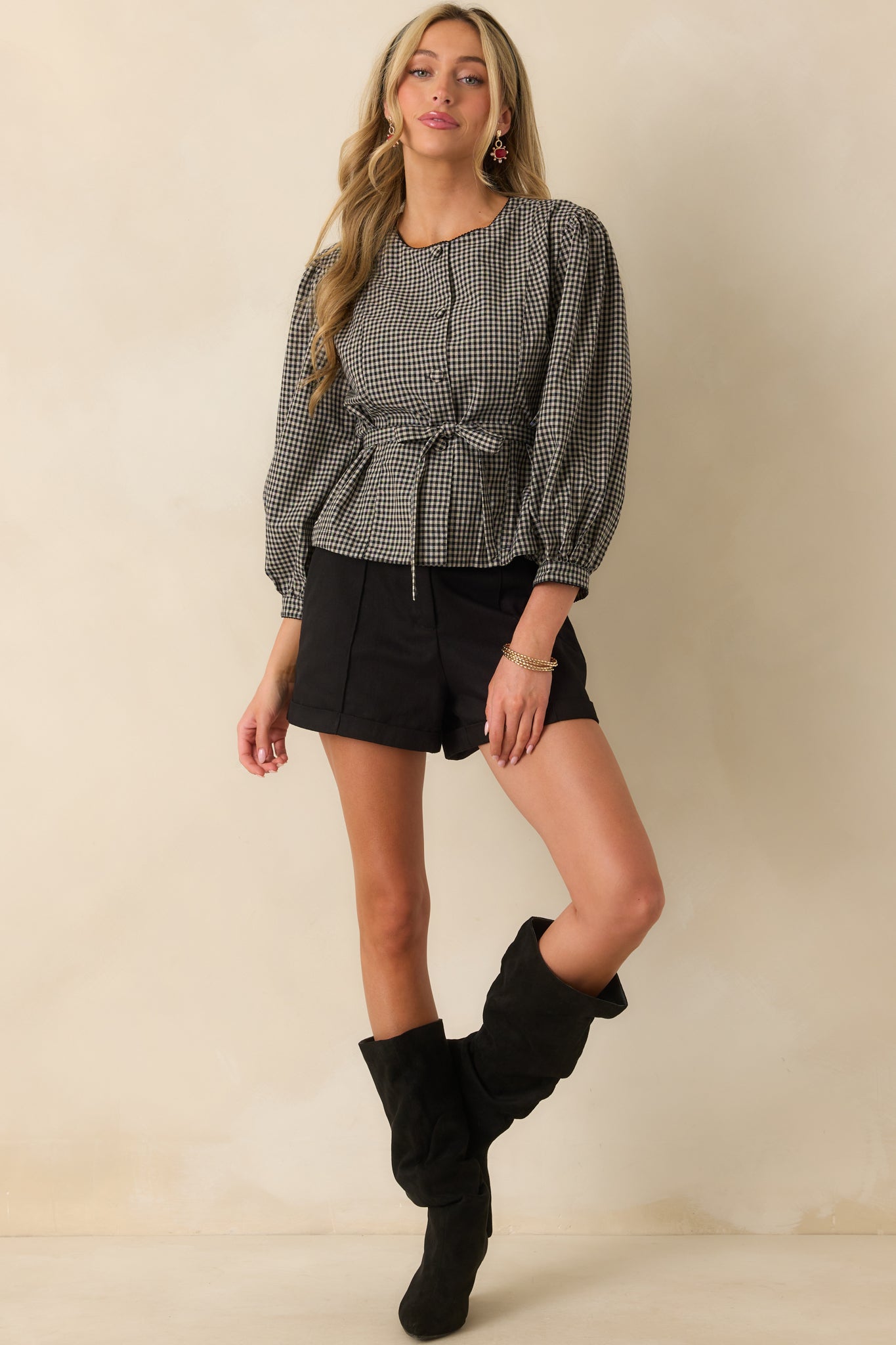 Front view of the black gingham blouse featuring a relaxed silhouette with puff sleeve detail.