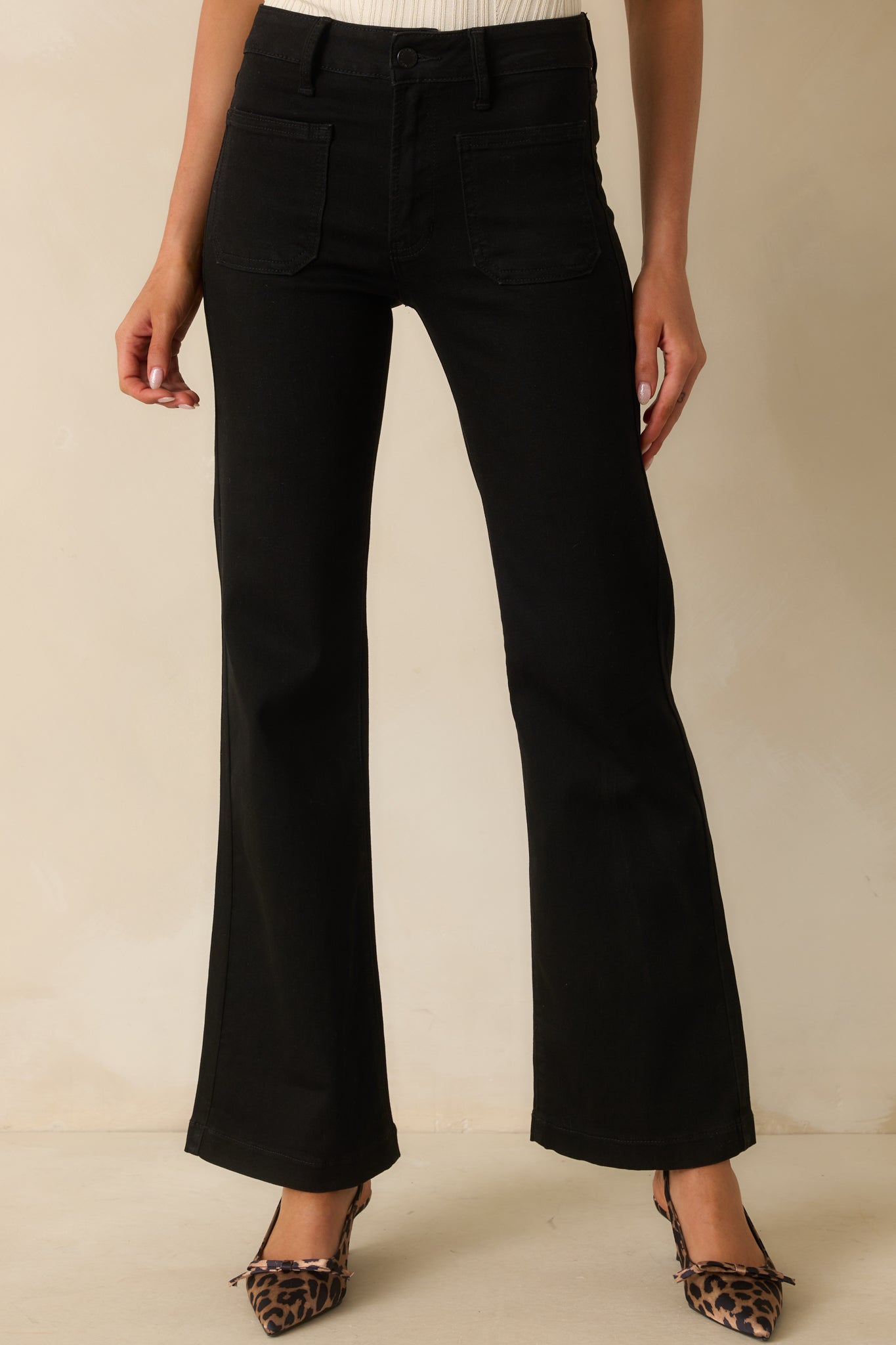 Black high-rise jeans with a flared leg silhouette and classic zipper button closure.