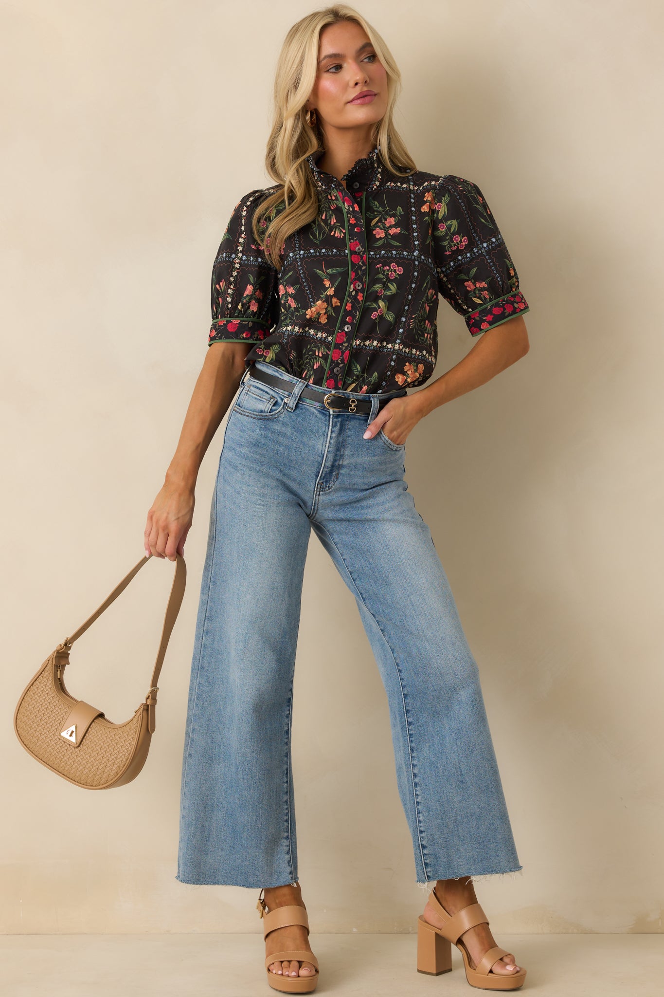 A front-facing look at the black top featuring a round neckline, relaxed fit, and short puff sleeves.