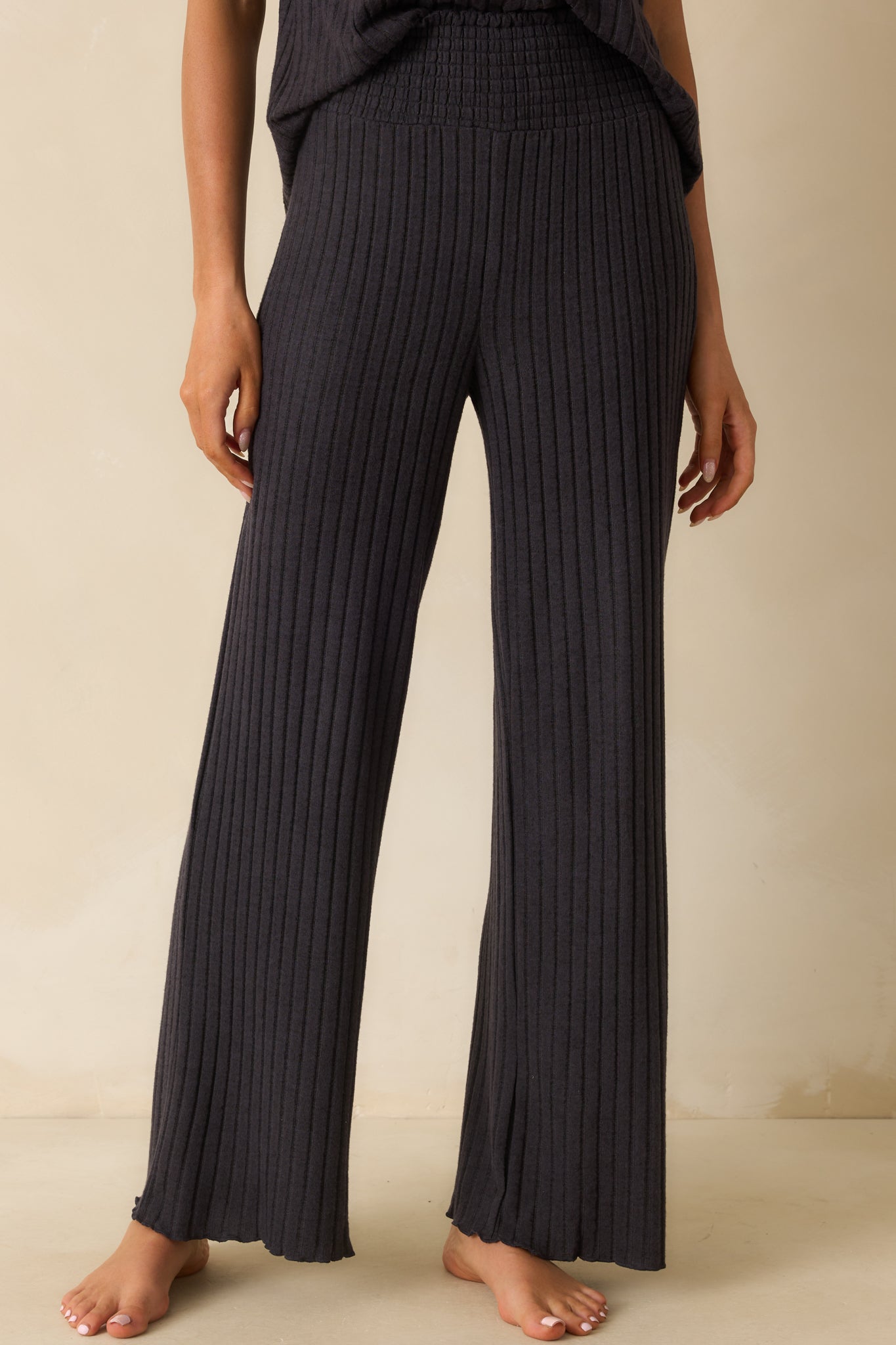 Black pants with a silky rib fabric and flowy wide leg silhouette.