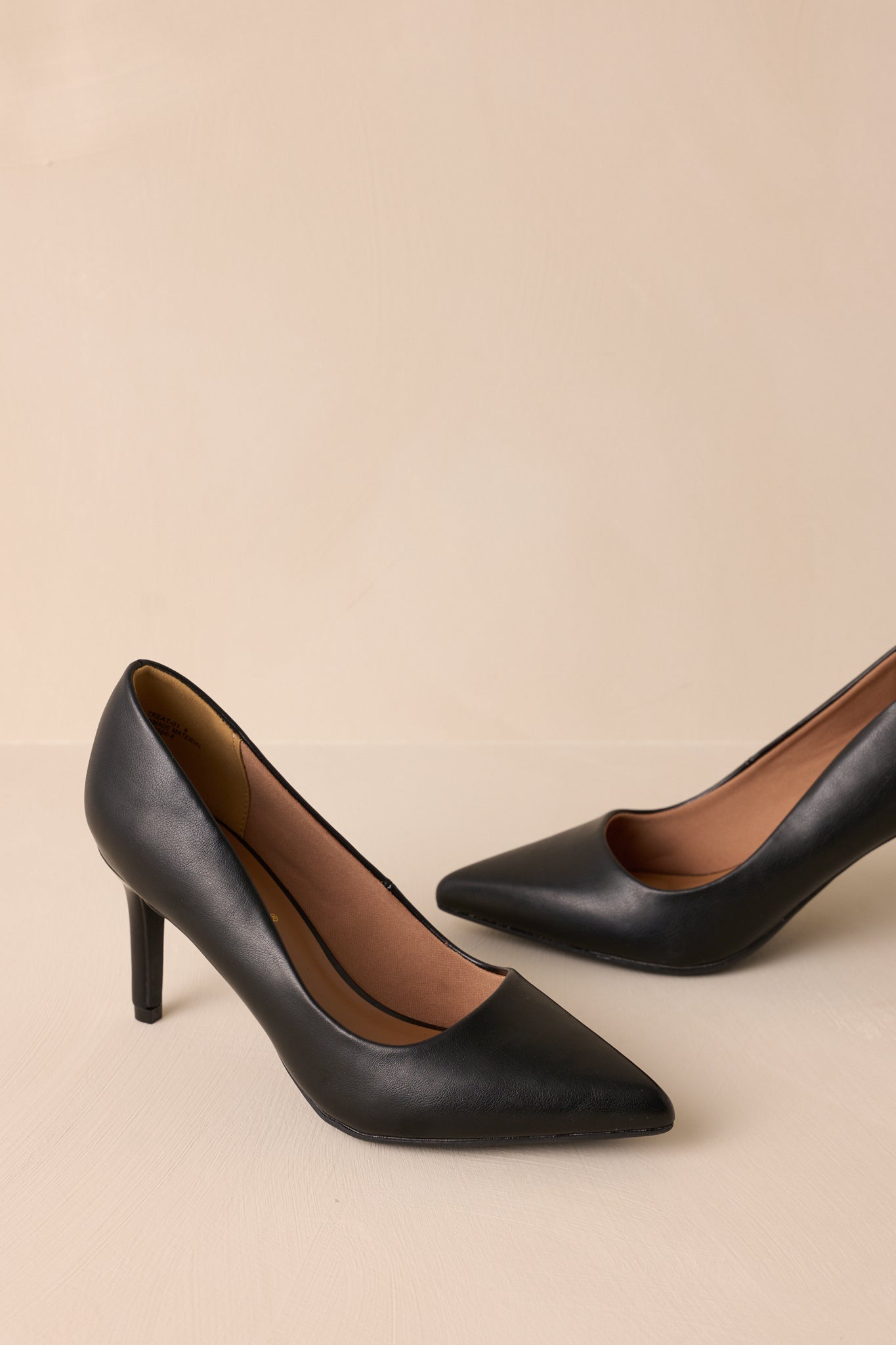 Front angle of the pumps highlighting the sleek black finish and pointed toe