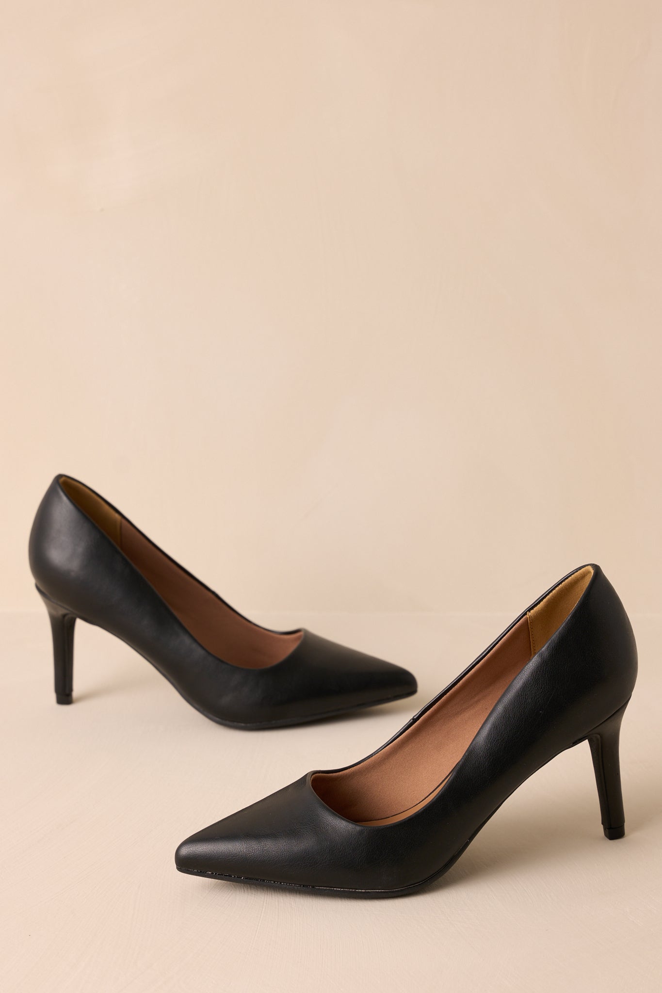 Three-quarter view of the black heels emphasizing the cushioned midsole.