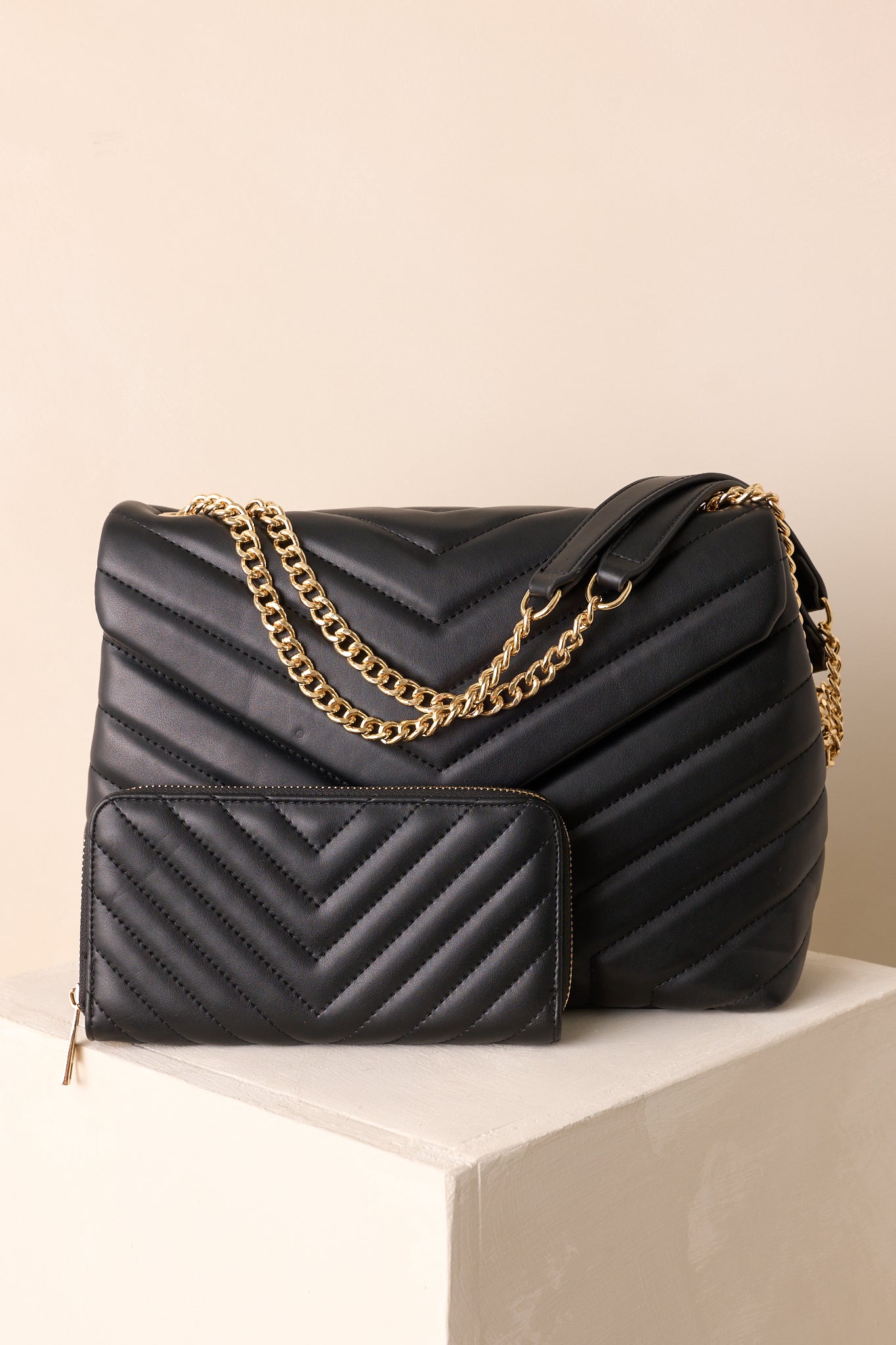 The black rectangle handbag highlighting its quilted texture and matching wallet detail.