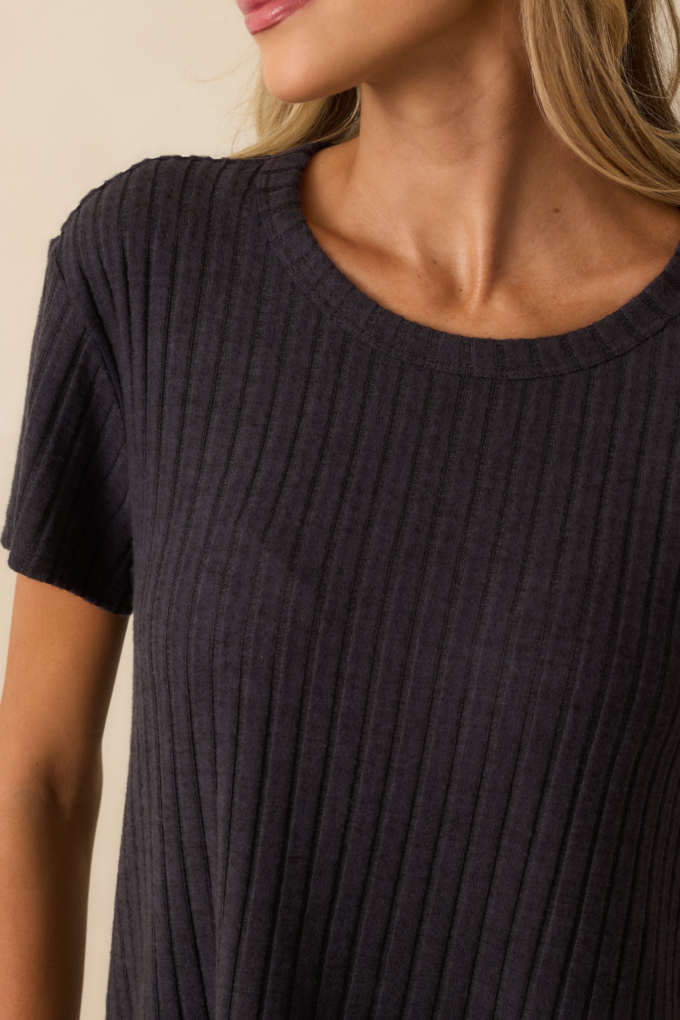 Detailed look at the ribbed texture and silky fabric finish of the black tee.