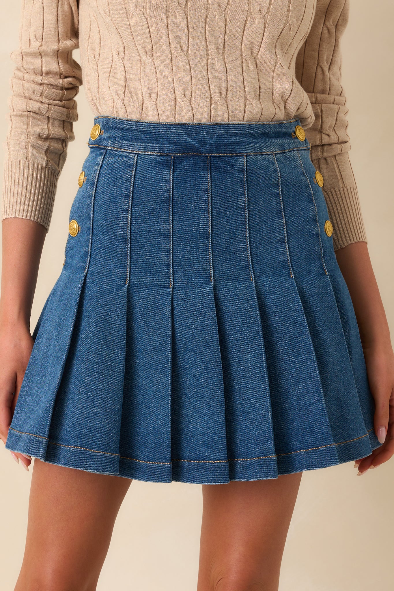 Cropped front view focusing on the embossed gold buttons and texture of the cotton-blend denim fabric.