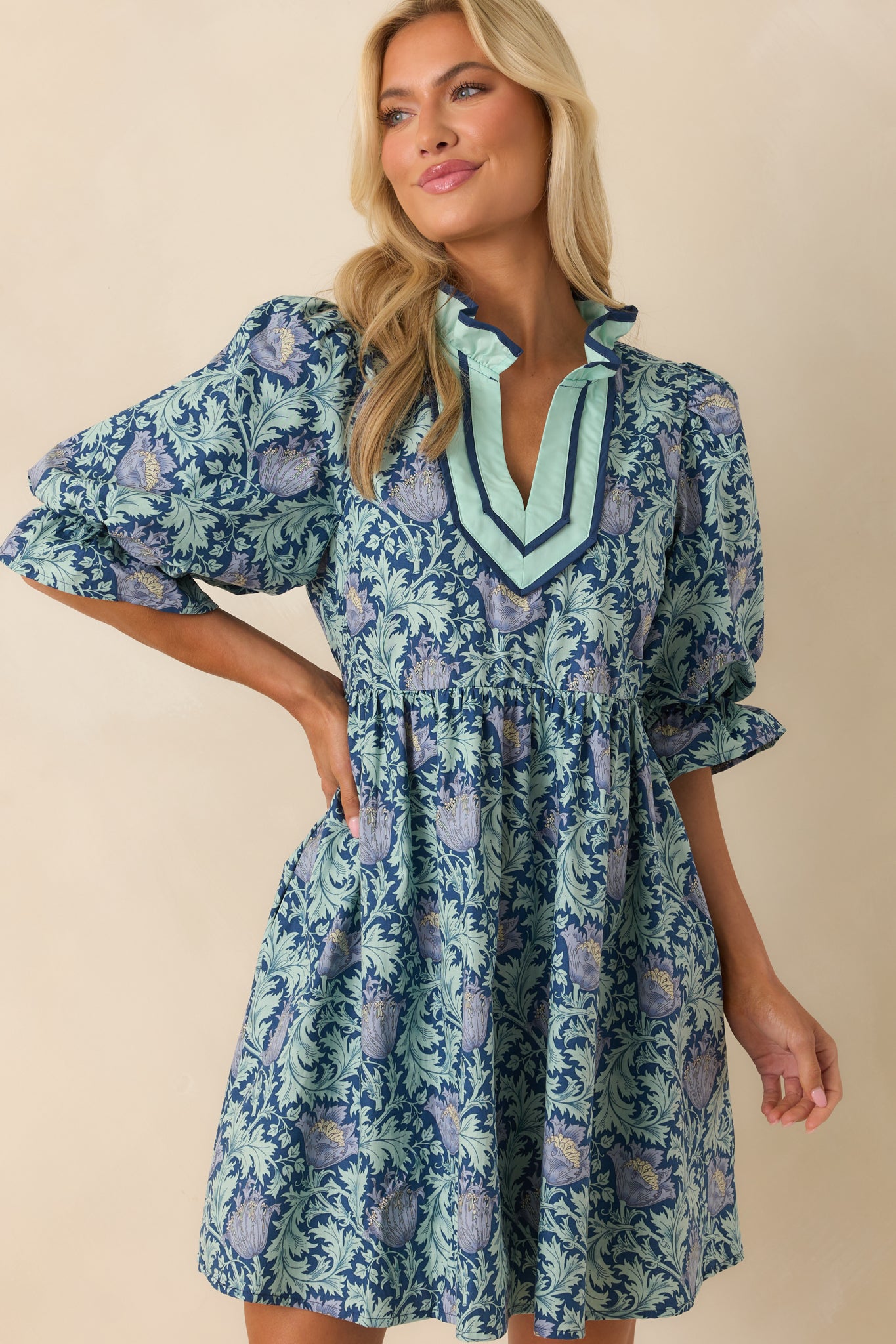 Cropped image focusing on the multicolor floral fabric and texture of the navy mini dress.