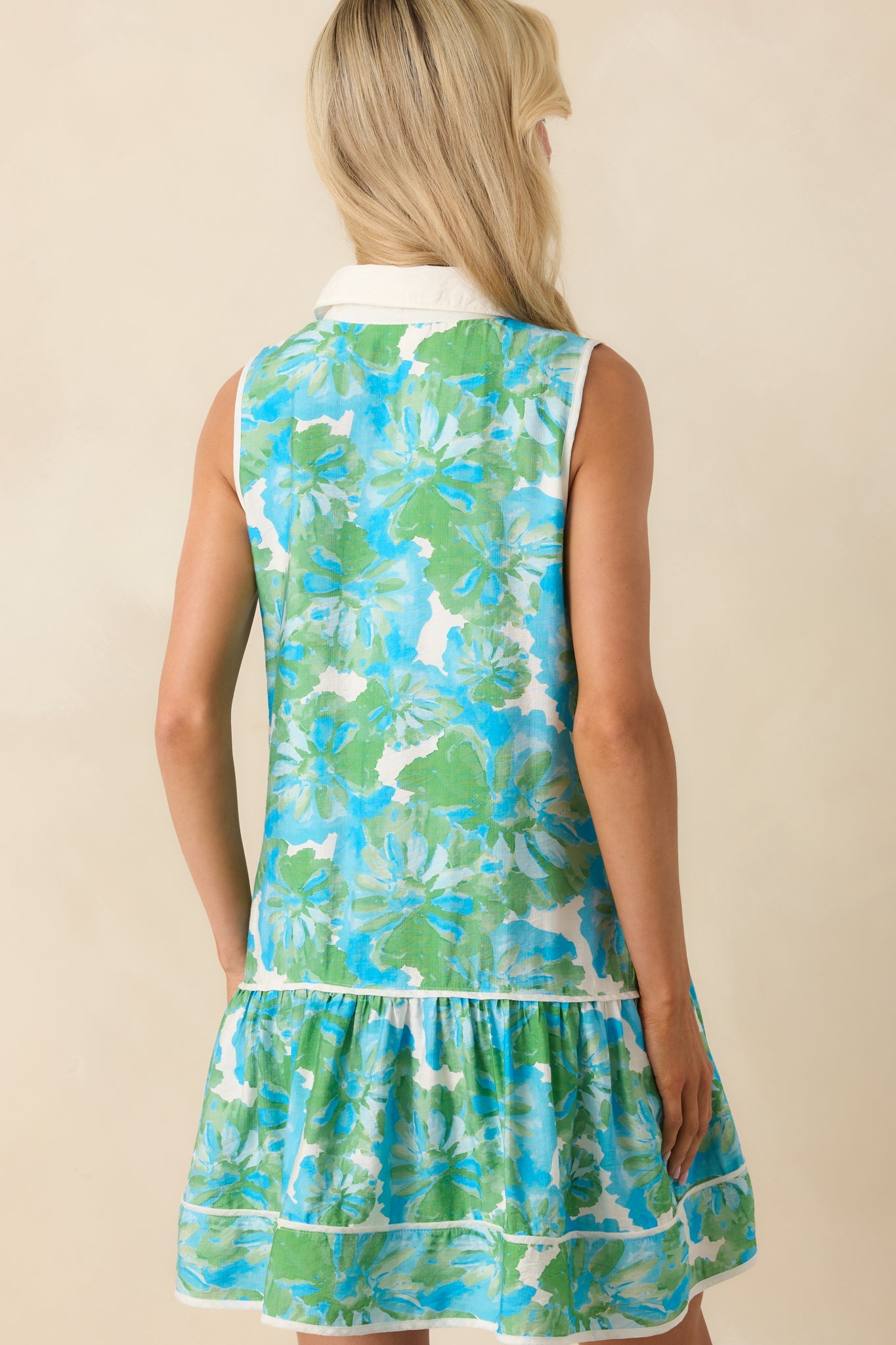A view from behind showing the continuation of the watercolor floral print and white contrast trim along the collar and hem.