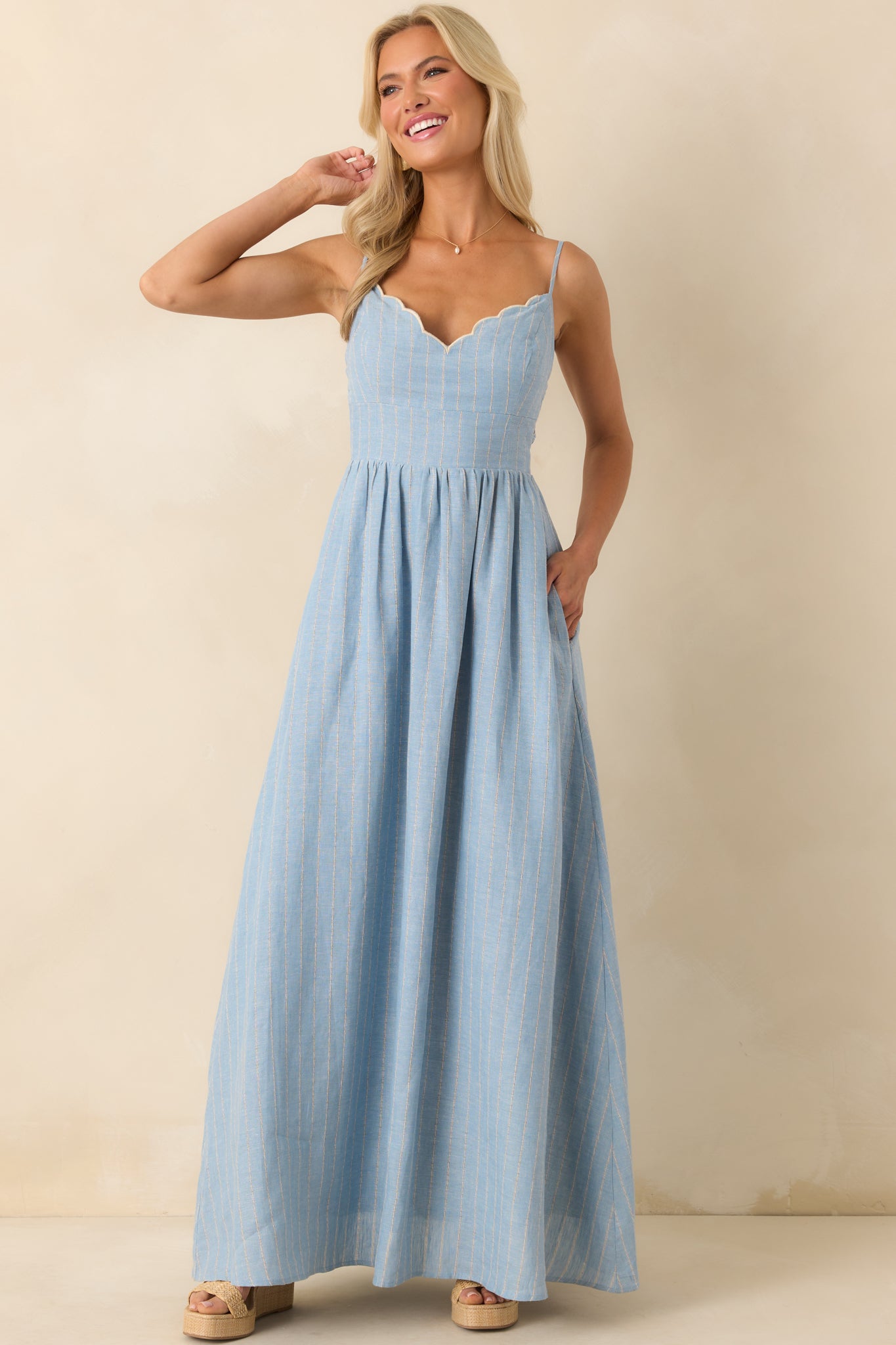 A full body front view of the light blue maxi dress featuring an ivory pinstripe pattern and scallop trim v-neckline.