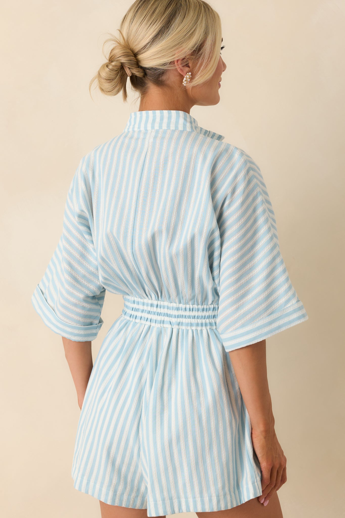 Back view of light blue striped romper showcasing elastic waistband and relaxed fit for a flattering look.