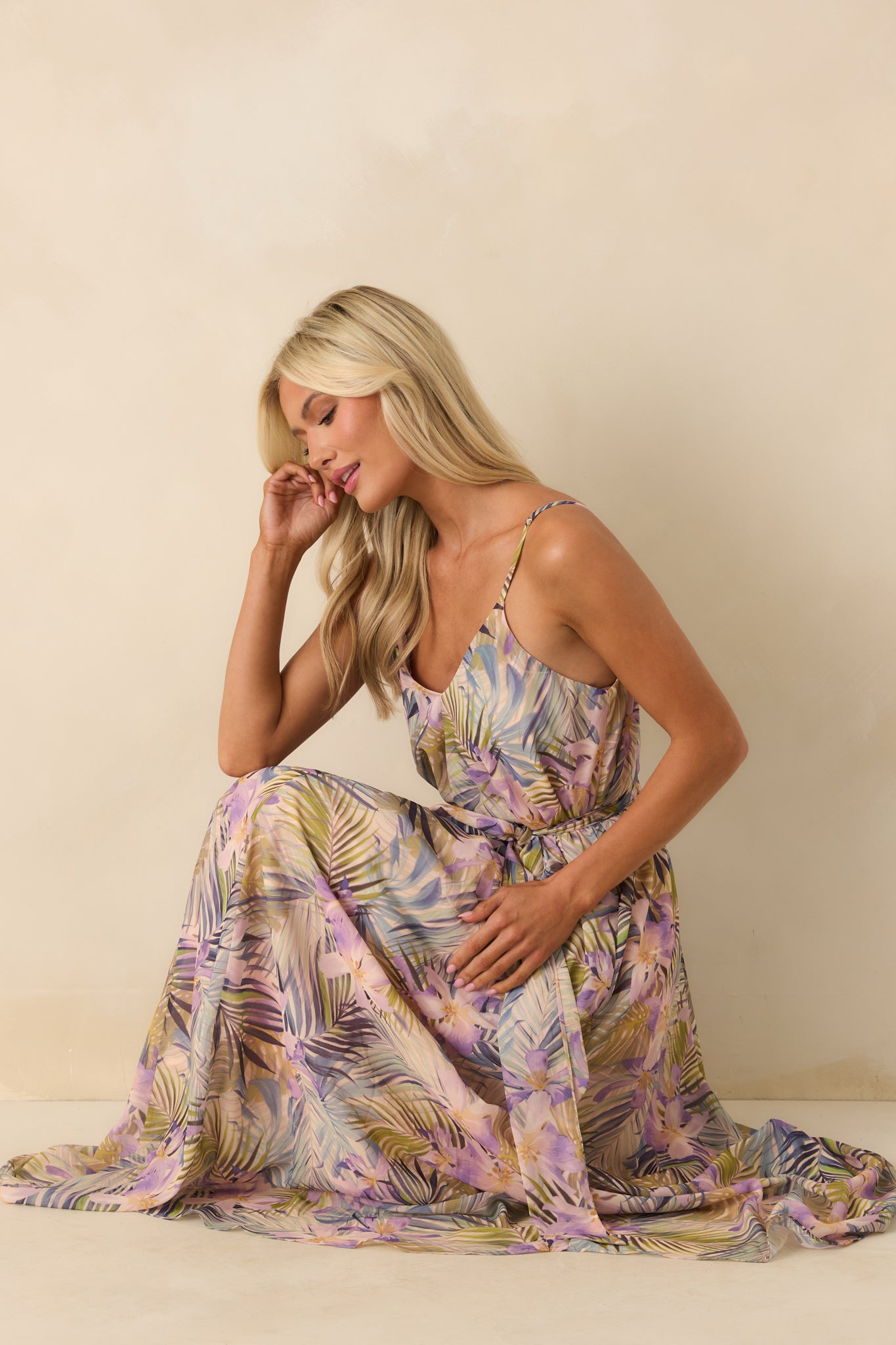 A posed shot displaying the optional self-tie belt styled at the waist and the vibrant tropical print across the maxi length.