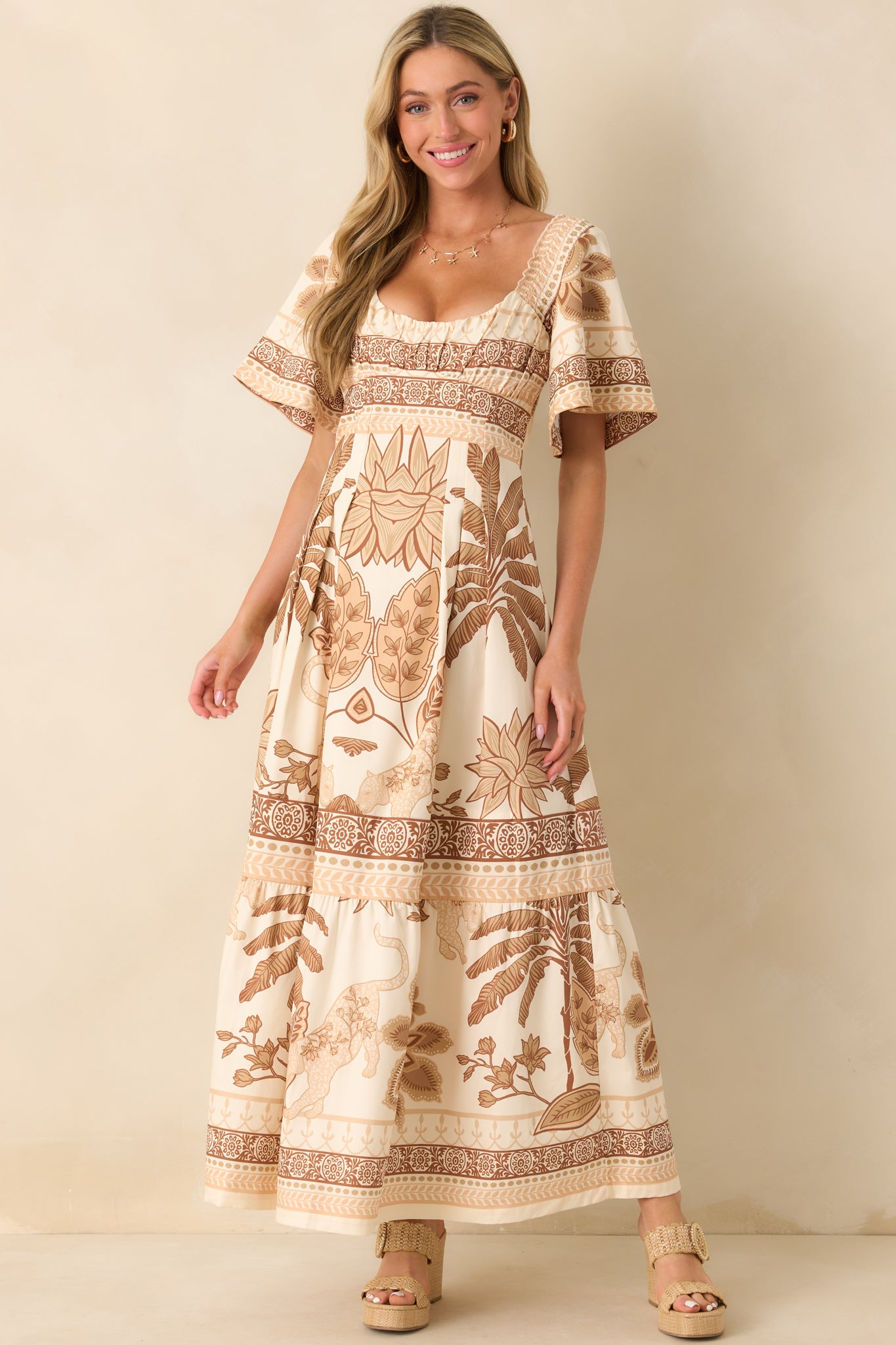 Full body front view of the beige multi-print maxi dress featuring a scoop neckline and tiered skirt flowing to the hem.
