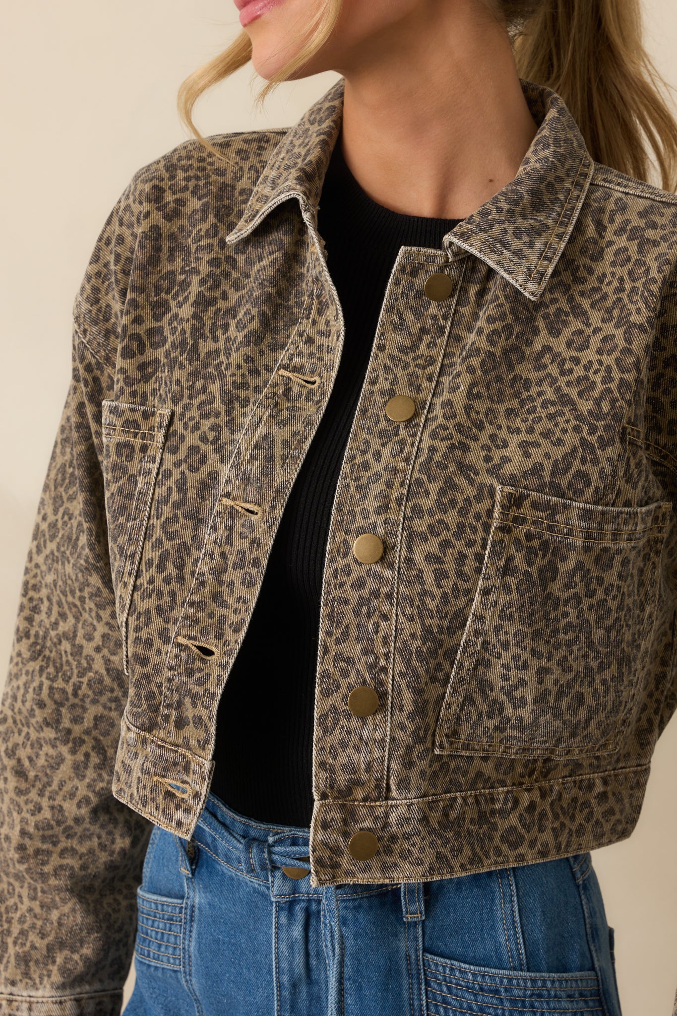 Brass-toned snap hardware and washed leopard texture shown in detail.