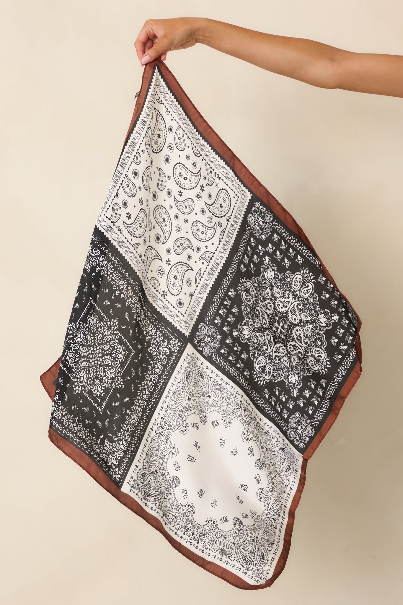 Brown, black, and ivory paisley bandana scarf featuring a patchwork-inspired print with a contrasting brown border.