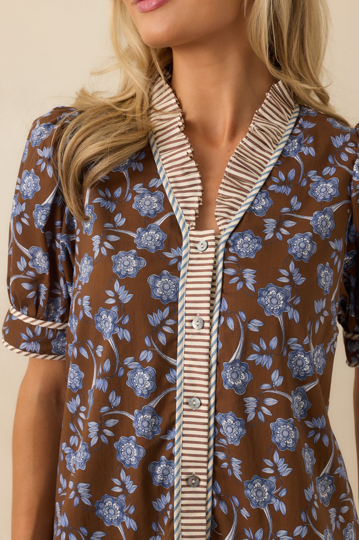Detailed view of the blue floral print with brown and ivory striped trim accents