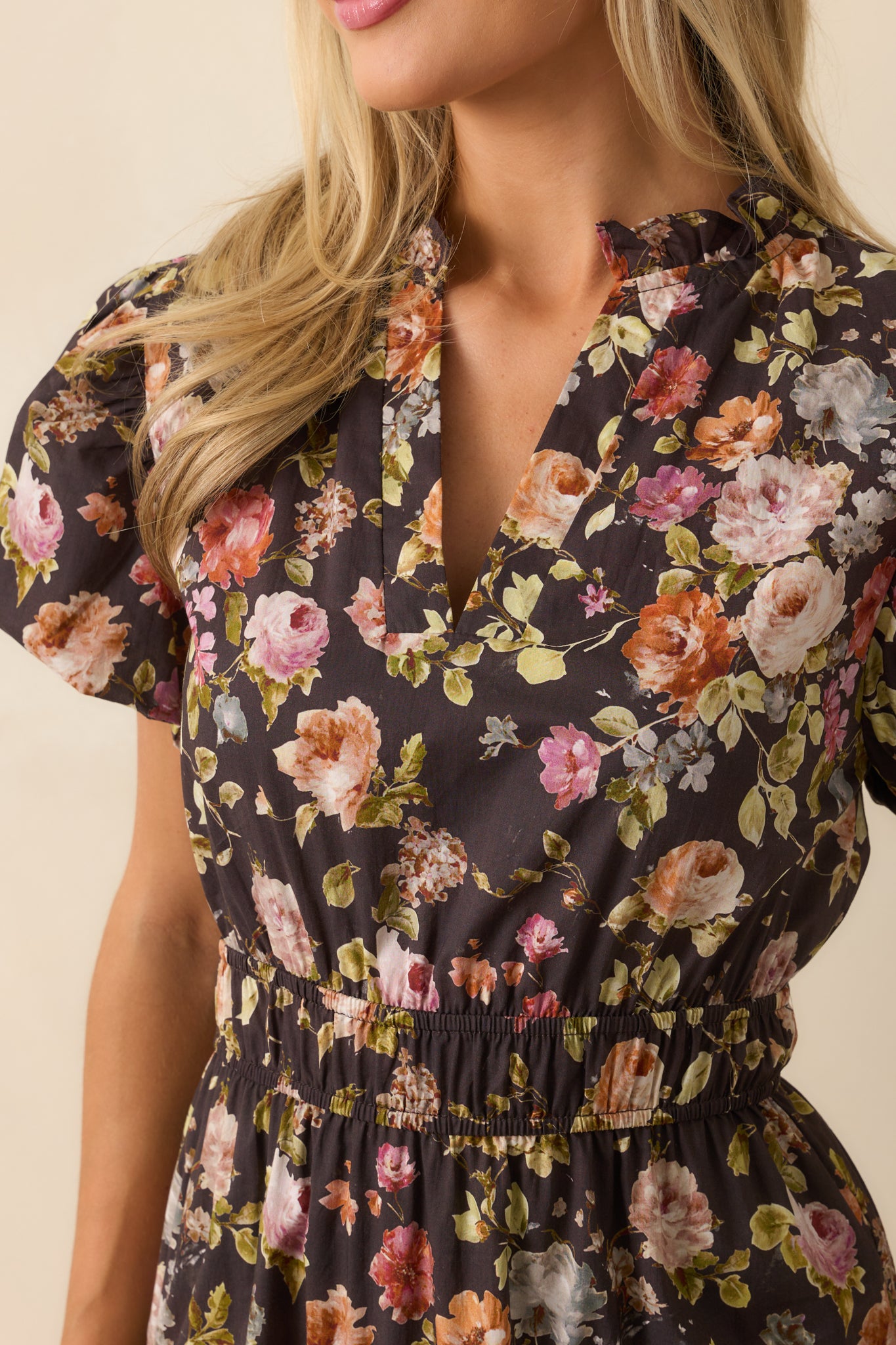 Detailed view of floral print and ruffle trim on the brown maxi dress.