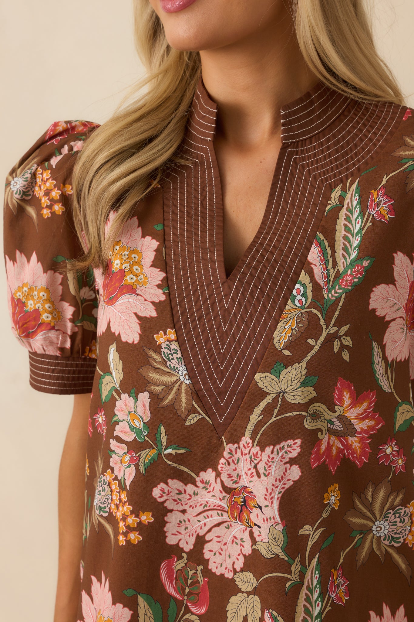 Close-up of the pink multicolor floral print and white topstitch trim.